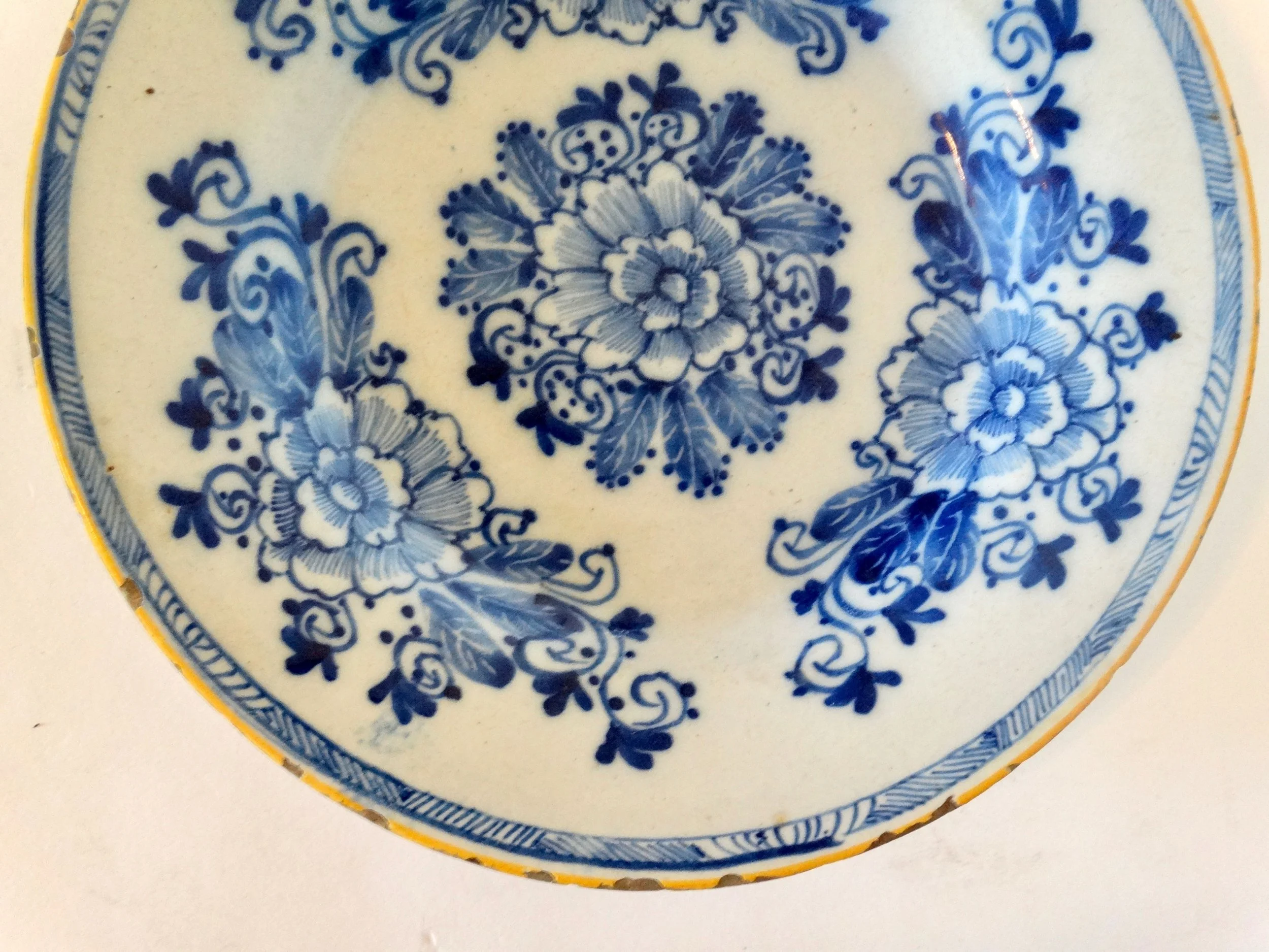 18th-century Dutch Delftware plate by Porcelayne Bijl with hand-painted floral design in blue.