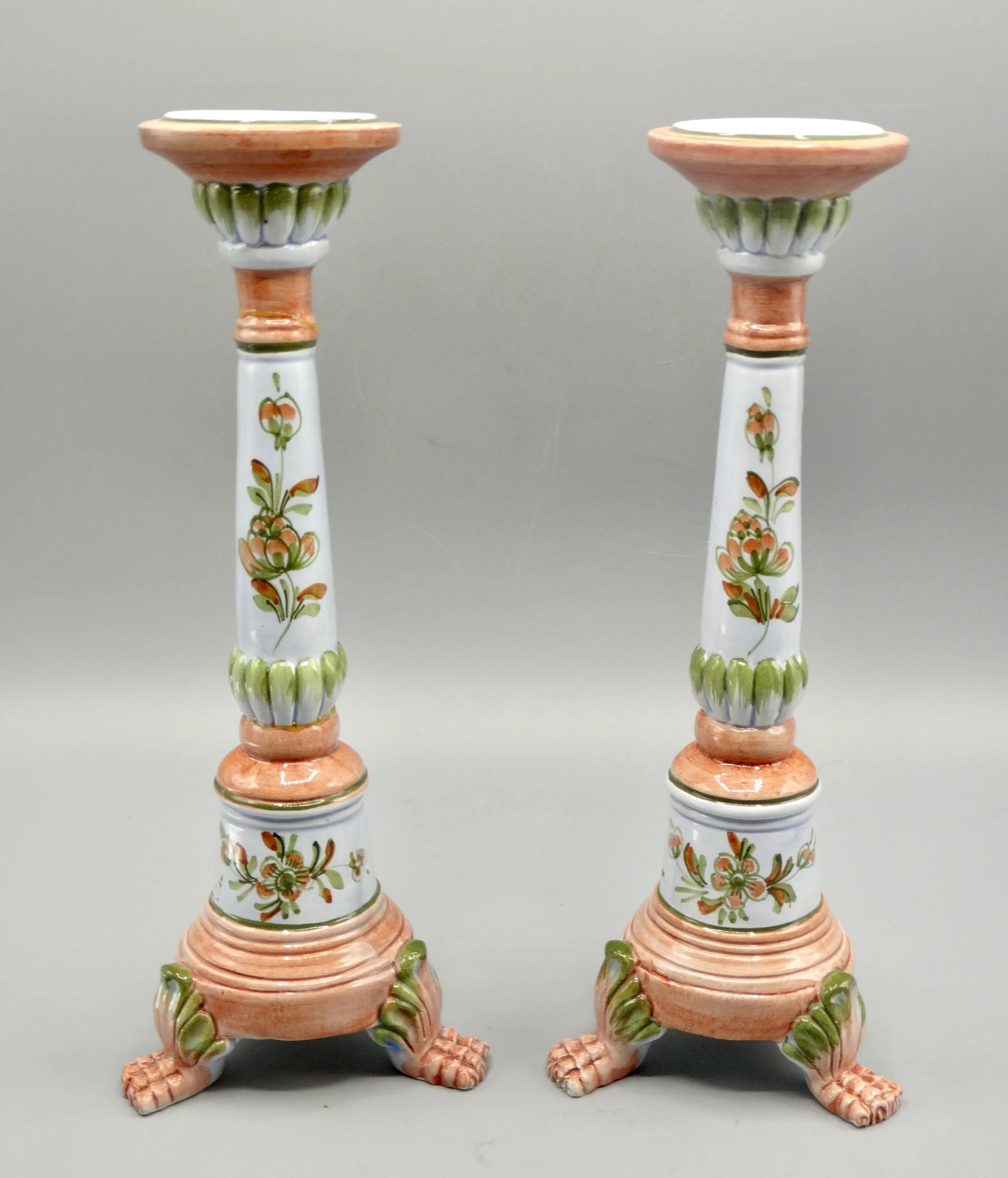 Pair of vintage Italian faience candlesticks, hand painted floral motif, raised on paw feet, mid-century Italy