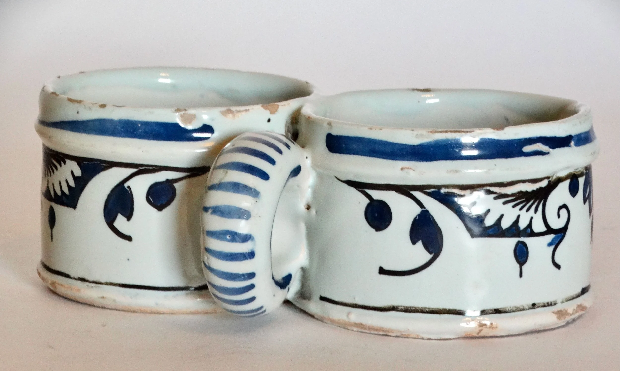 Close-up of handle on 18th-century Delft faience presentier double dish, hand painted with floral geometric design