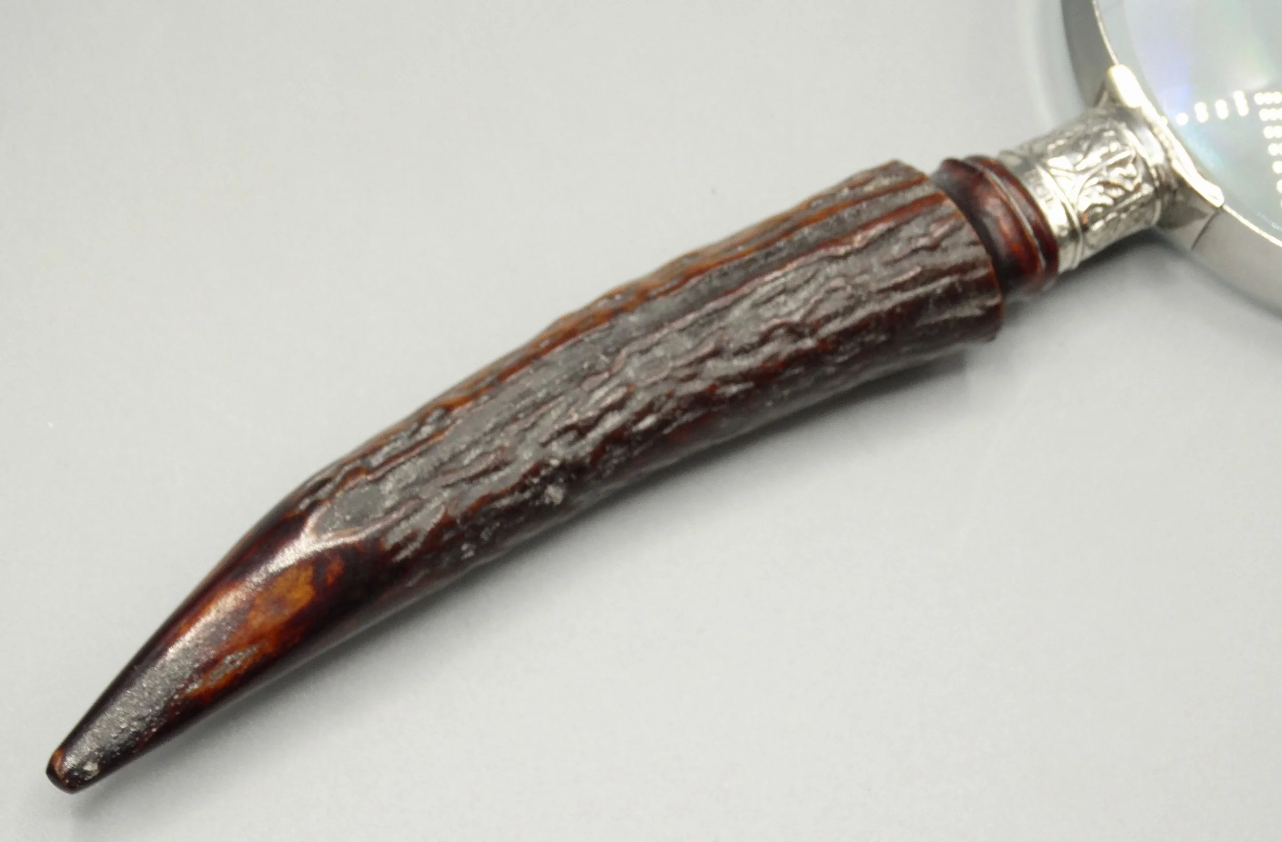 Detail of natural stag horn handle on antique magnifying glass with sterling silver mounts, hallmarked 1911