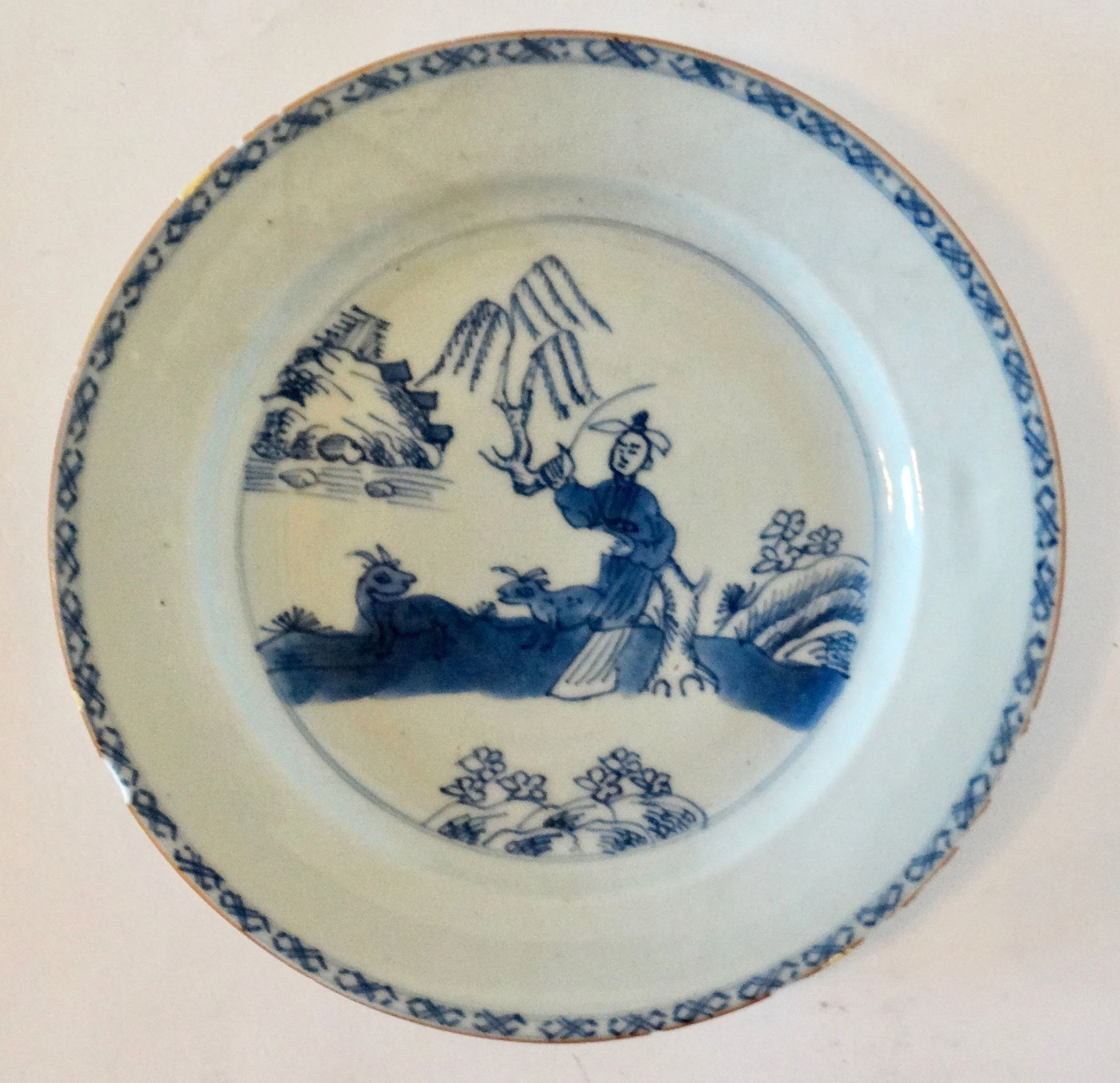 18th-century English Delftware chinoiserie plate, hand painted figure and animals, floral geometric border
