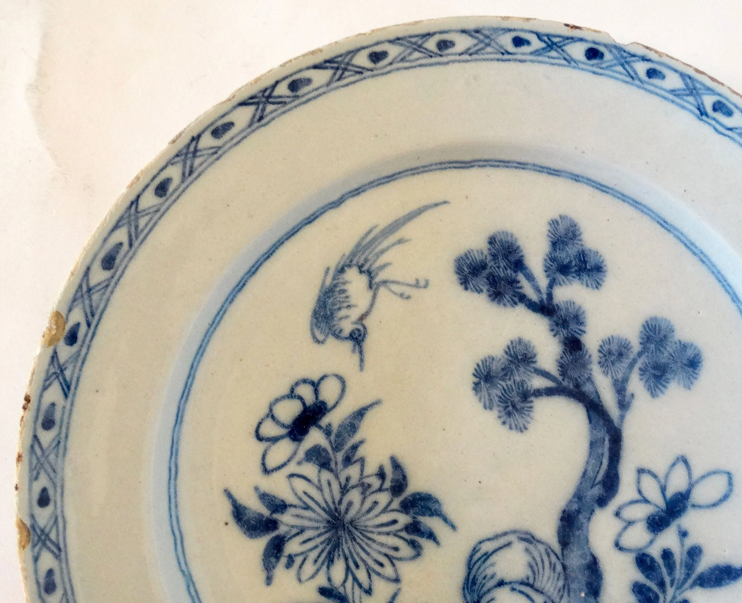 Rim detail of antique Delft blue and white chinoiserie charger.