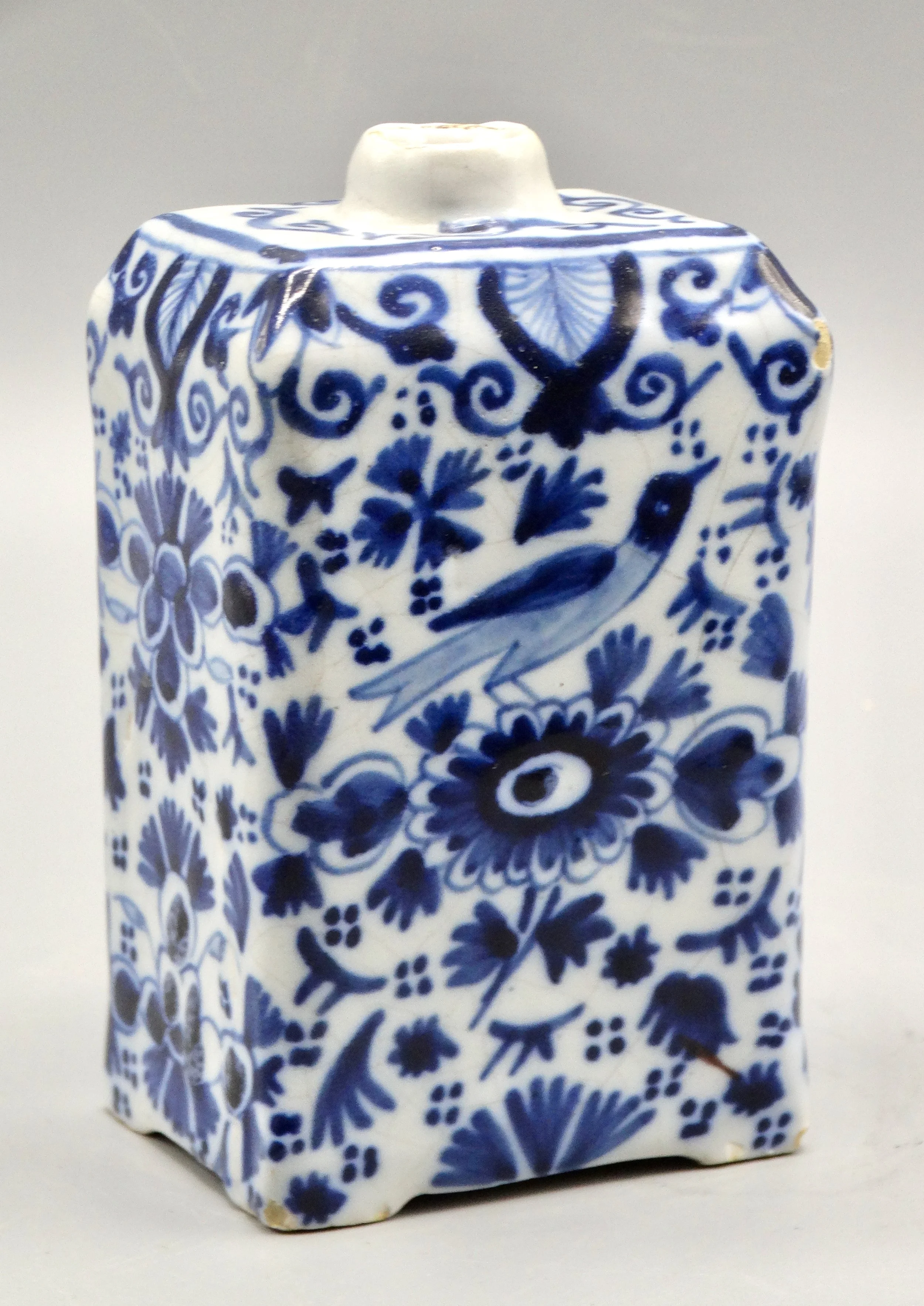 19th-century English Delft tea caddy with hand painted rampart lions, crown coat of arms, bird, and floral motifs.