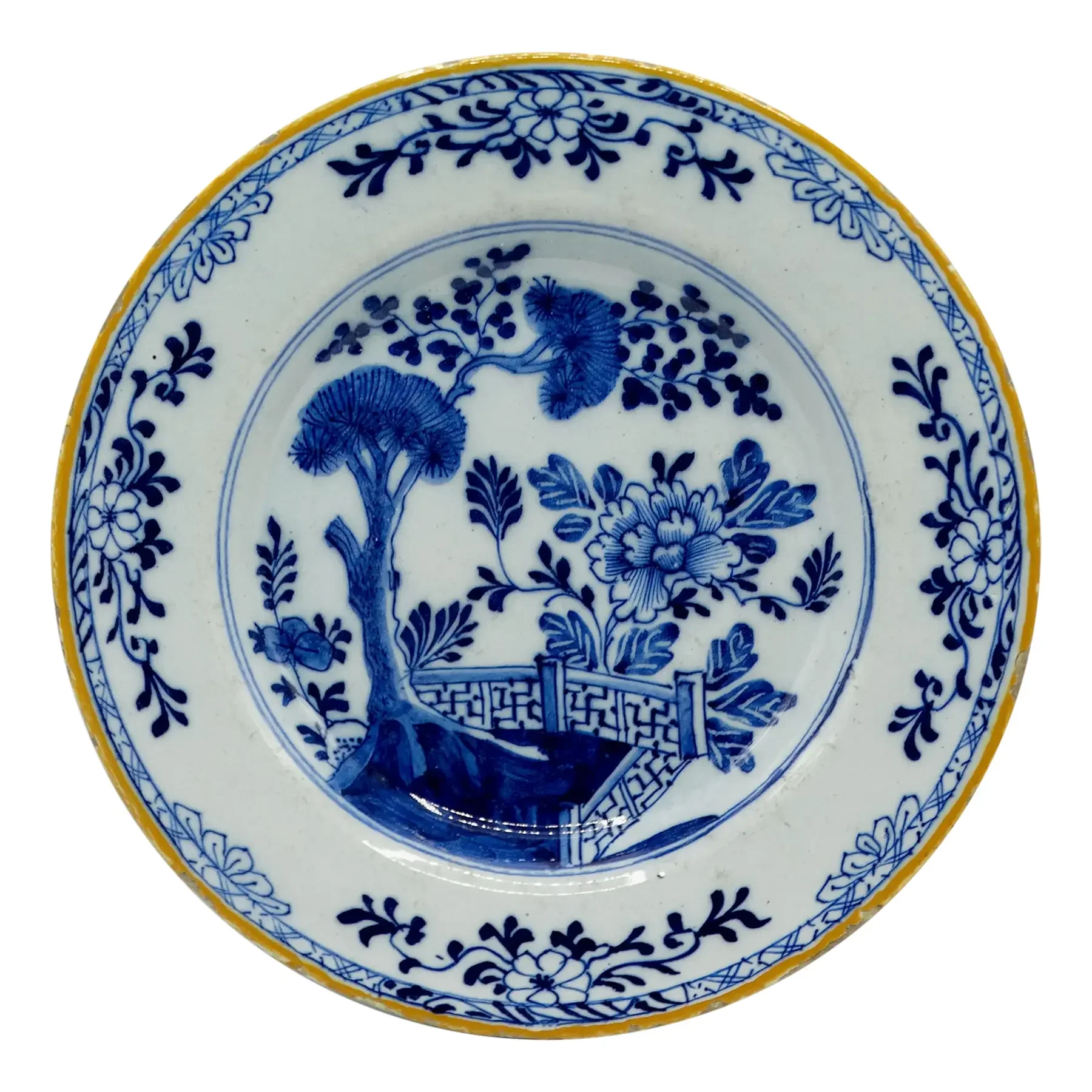 18th-century Dutch Delft chinoiserie plate by Porceleyne Bijl, hand painted with tree, fence, and floral motifs.
