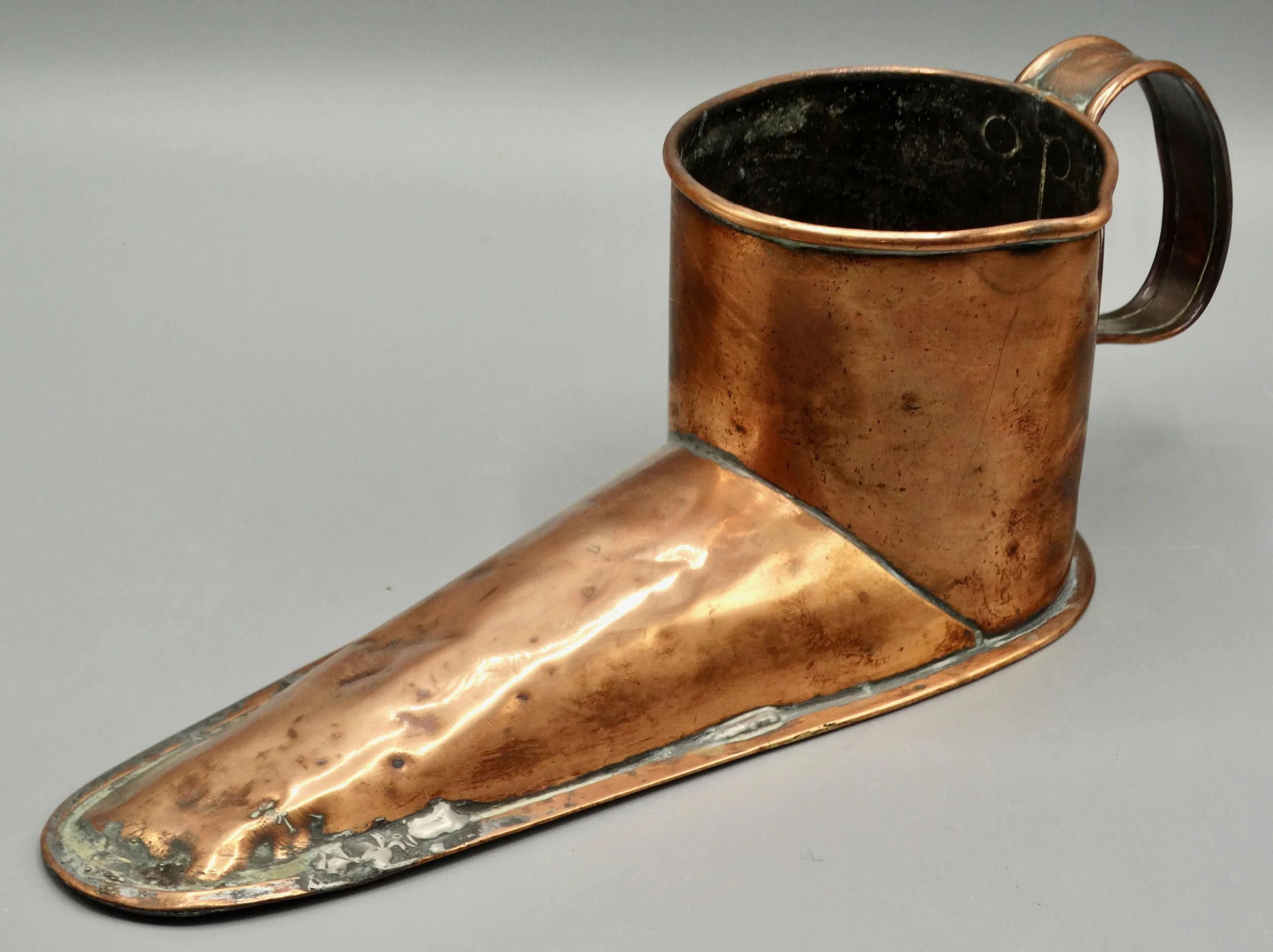 Side view of antique English copper ale warmer shaped like a boot, handcrafted 19th-century piece
