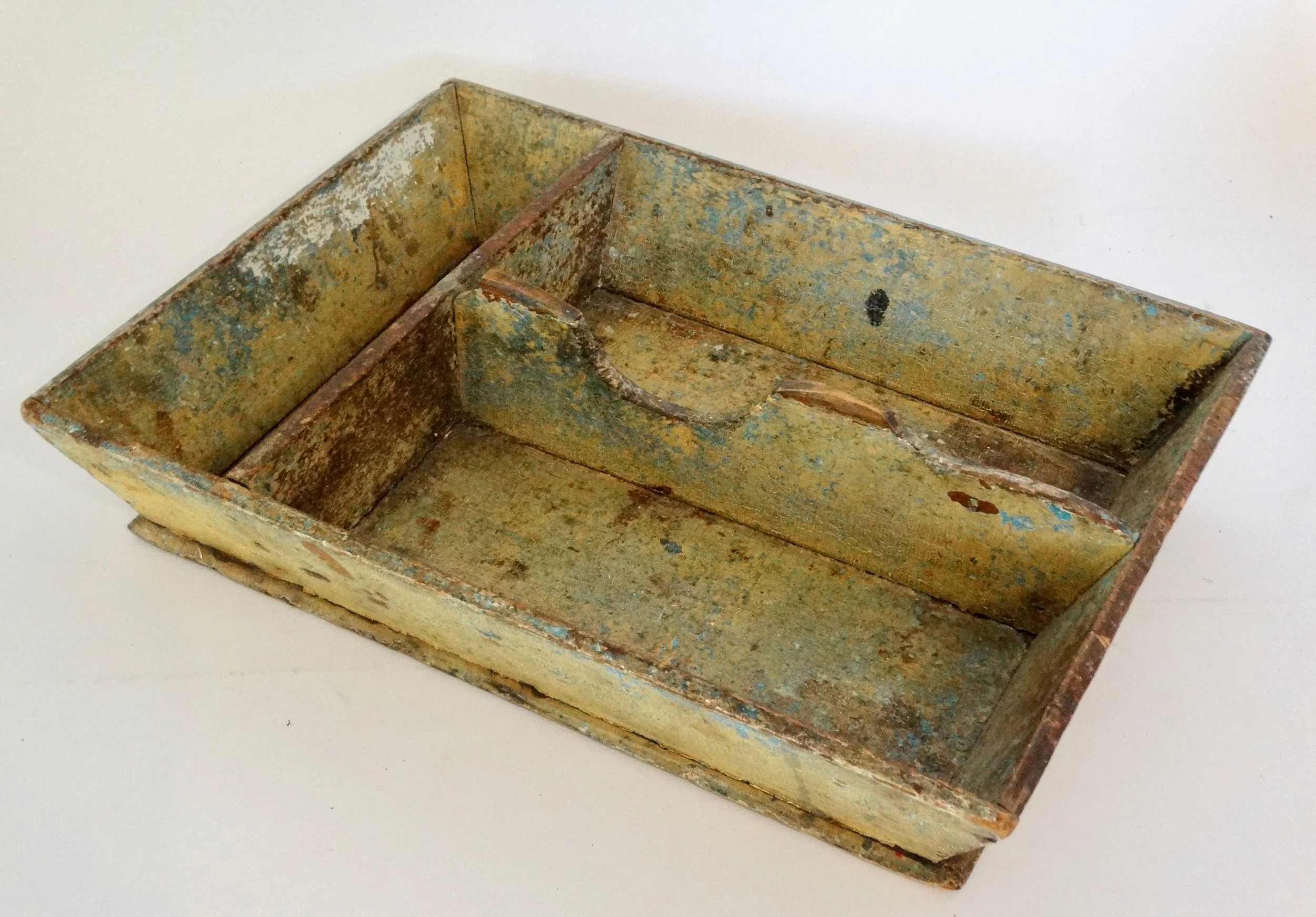 Early 19th-century American primitive cutlery tray in mustard colored paint with canted sides and protruding base.