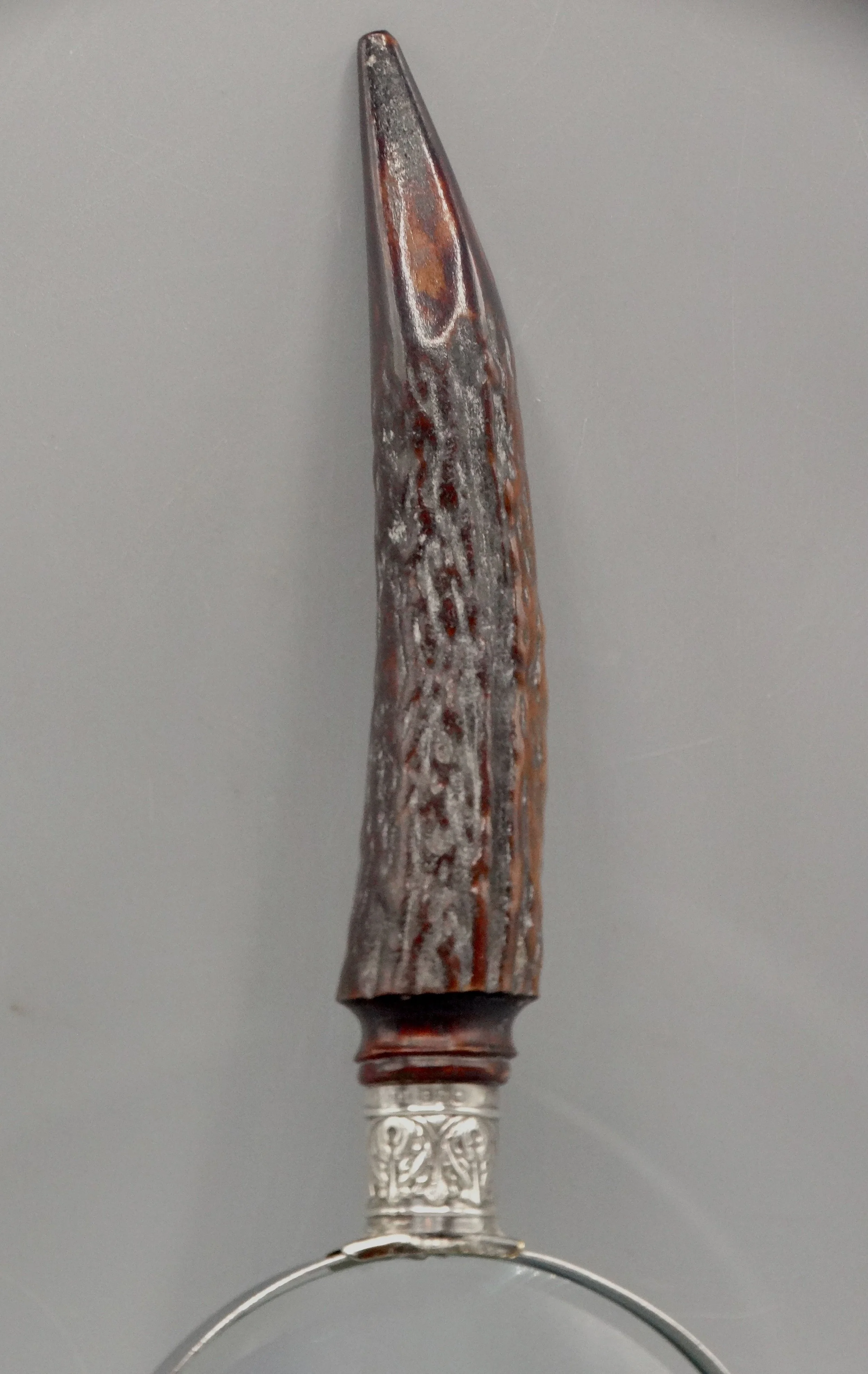 Detail of natural stag horn handle on antique magnifying glass with sterling silver mounts, hallmarked 1911