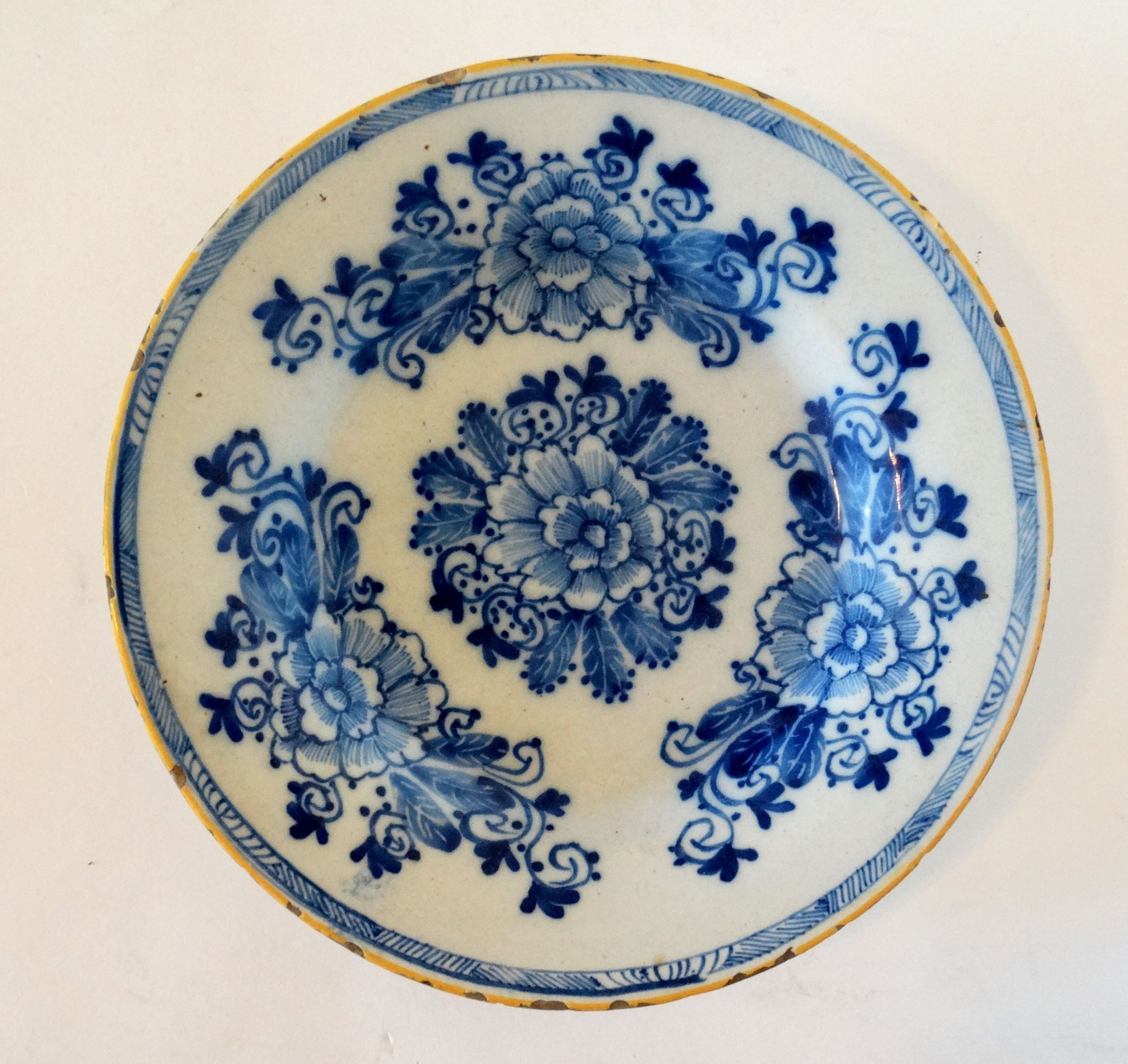 18th-century Dutch Delftware plate by Porcelayne Bijl with hand-painted floral design in blue.