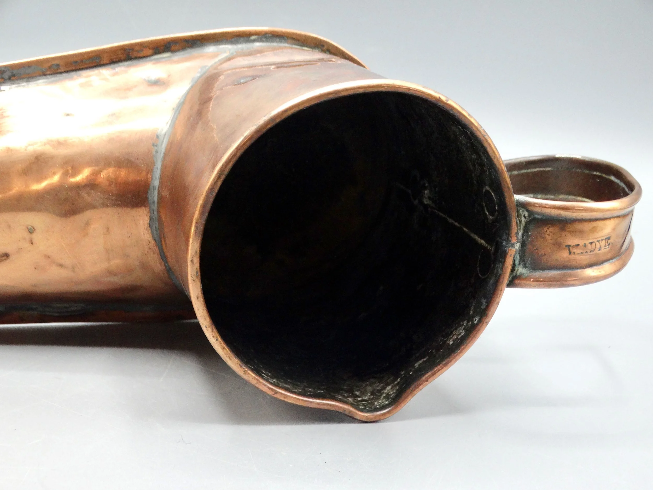 Top view of 19th-century English copper boot ale warmer, showing open mouth and handcrafted details