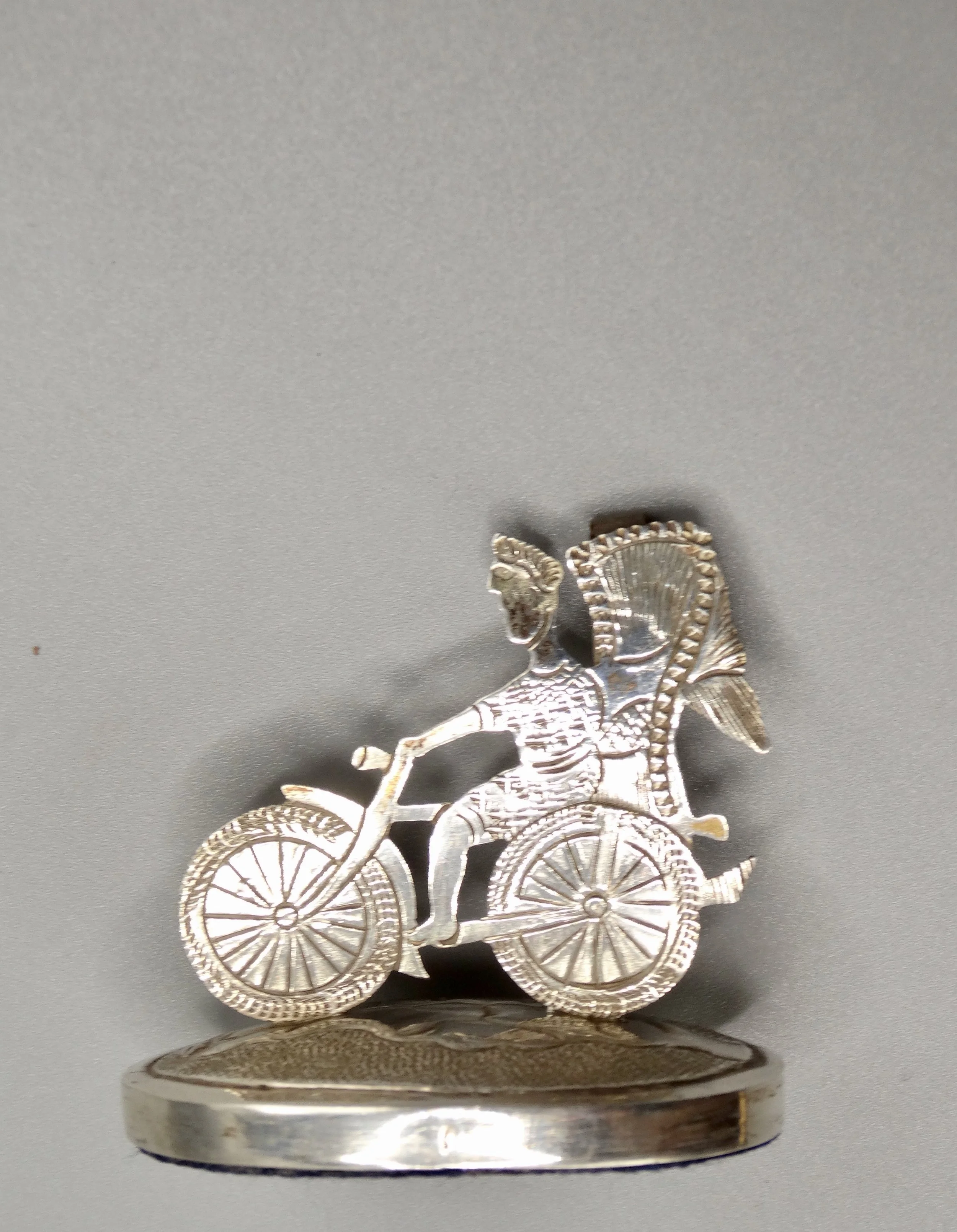 Close-up of finely handcrafted rickshaw and figure on Chinese sterling place card holder.