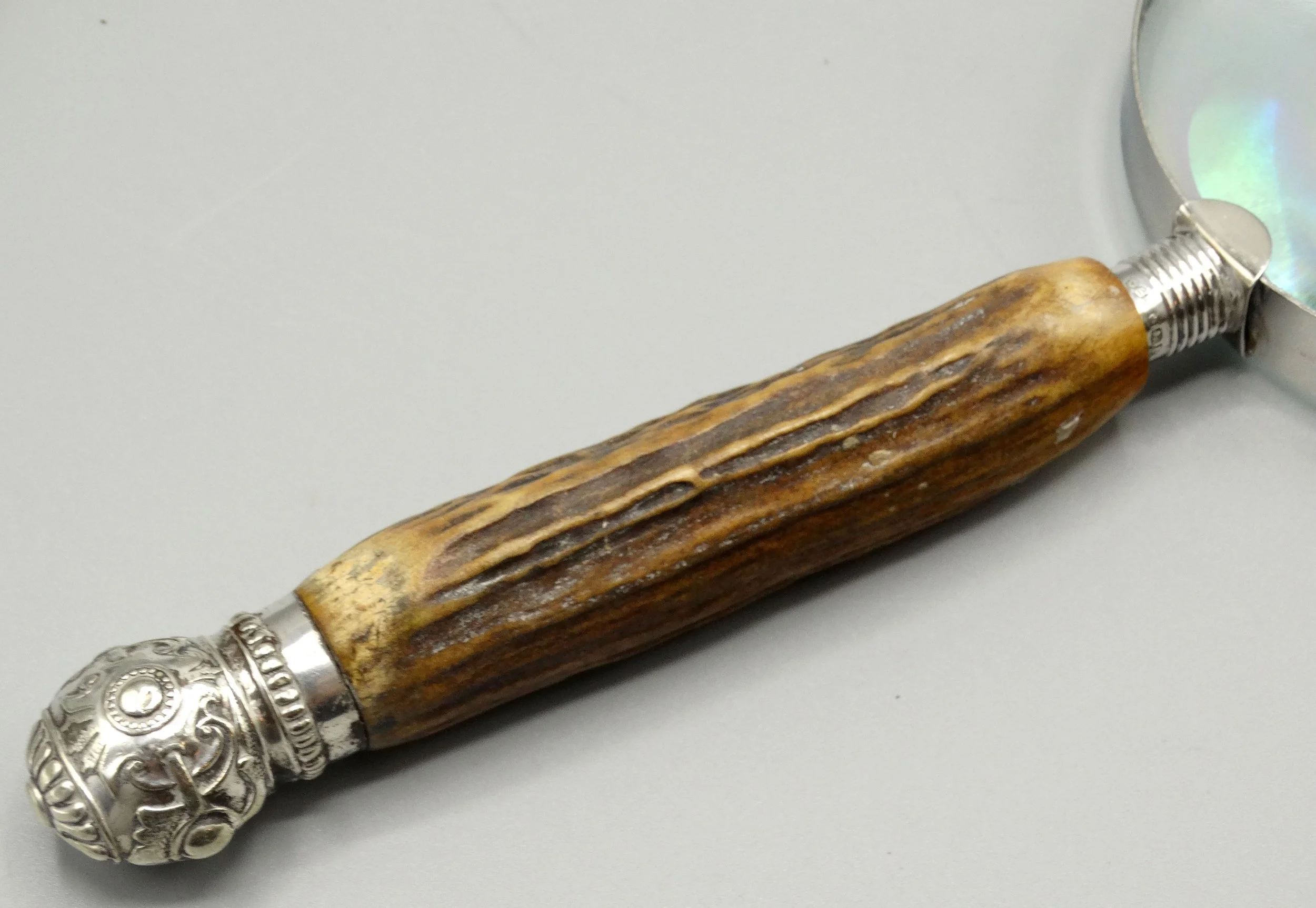 Detail of natural stag horn handle on antique English magnifying glass, silver mounts hallmarked John Biggin