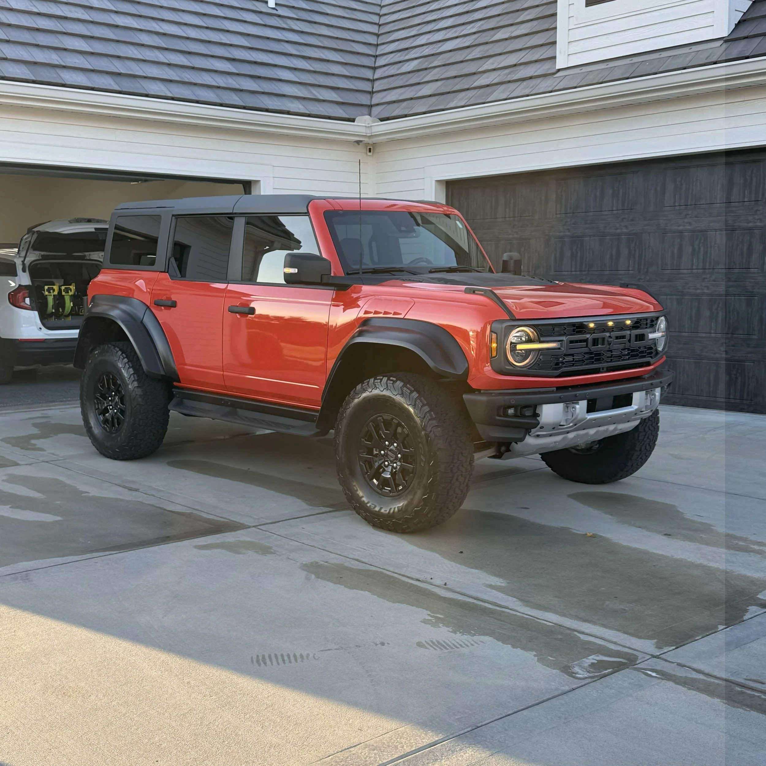 Red off-road SUV parked on a driveway with a garage in the background.