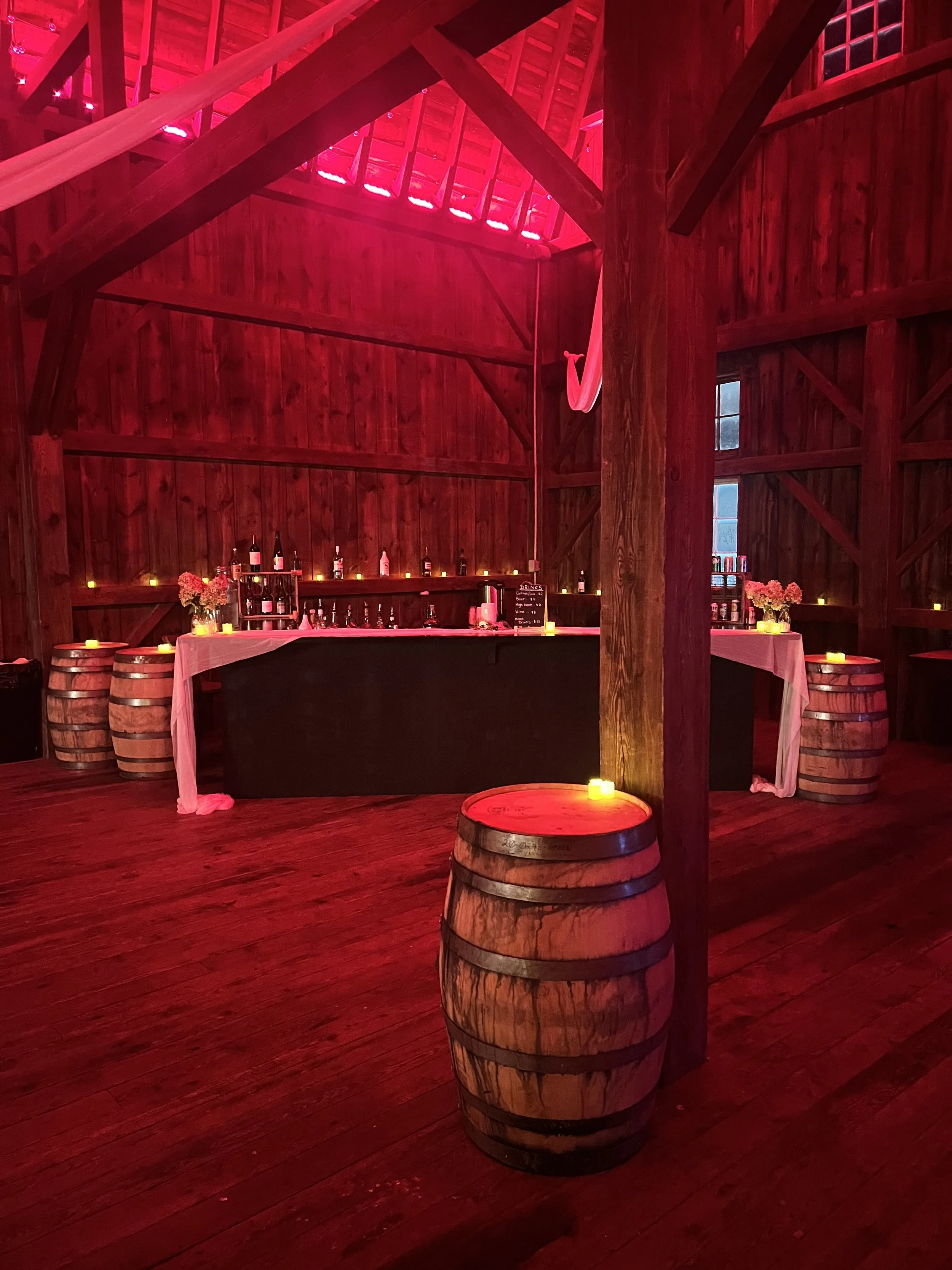 Three elderly people smiling and  wearing party hats with balloons in the background