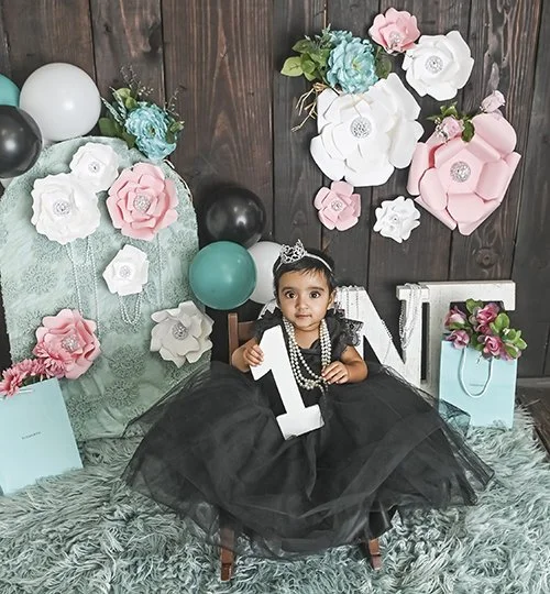 first birthday photoshoot girl holding the number 1