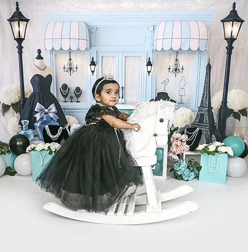 first birthday portraits girl riding a rocking horse wearing a black tutu