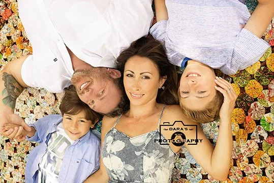 family photographer in South Florida family laying head to head on a quilt outside