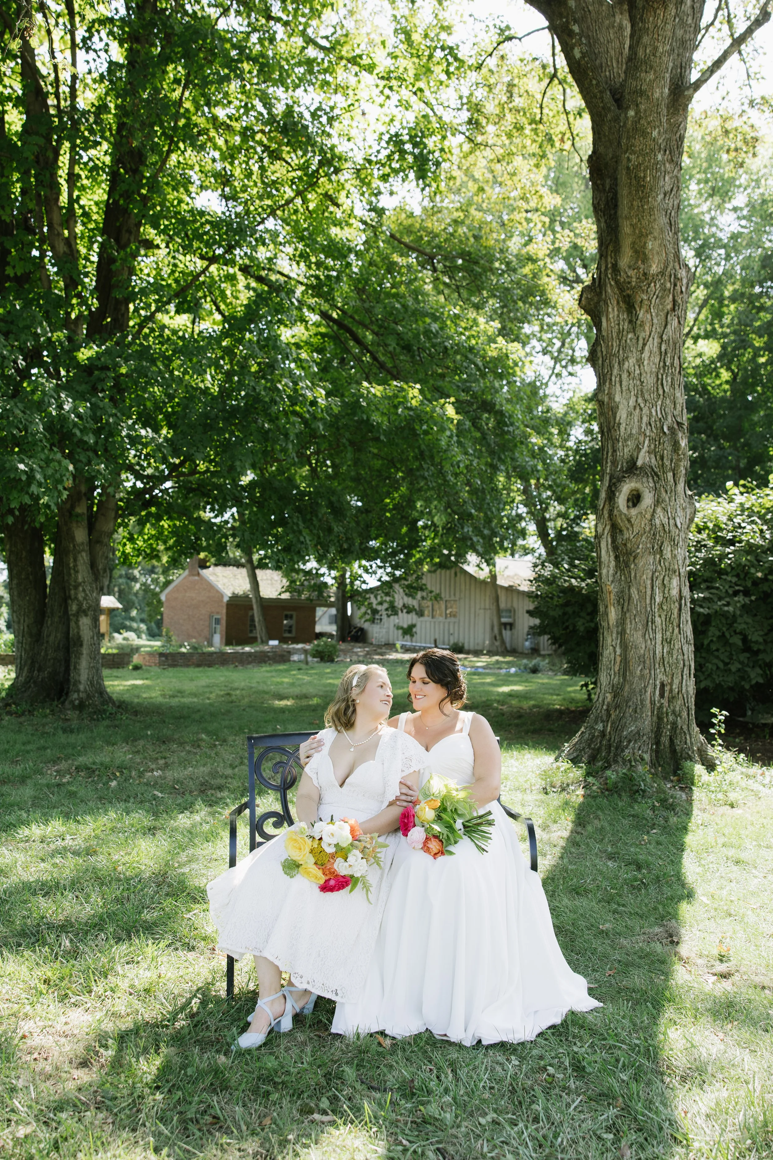 Outdoor wedding ceremony with a bride and groom exchanging vows under an arch, surrounded by seated guests on a rooftop with city skyline view in the background.