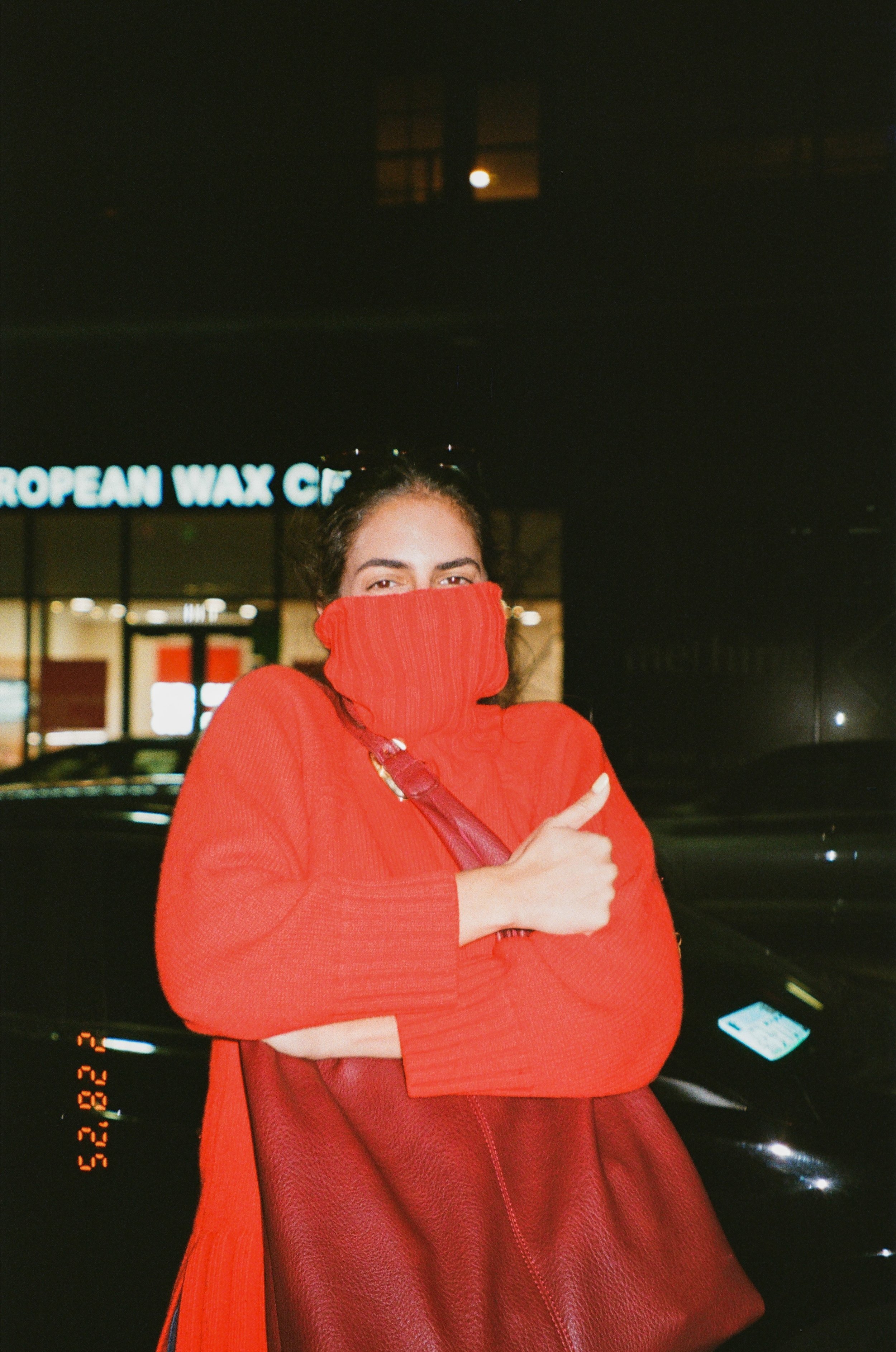 Woman in red sweater outside at night, captured in candid wedding photography near Miami, Florida