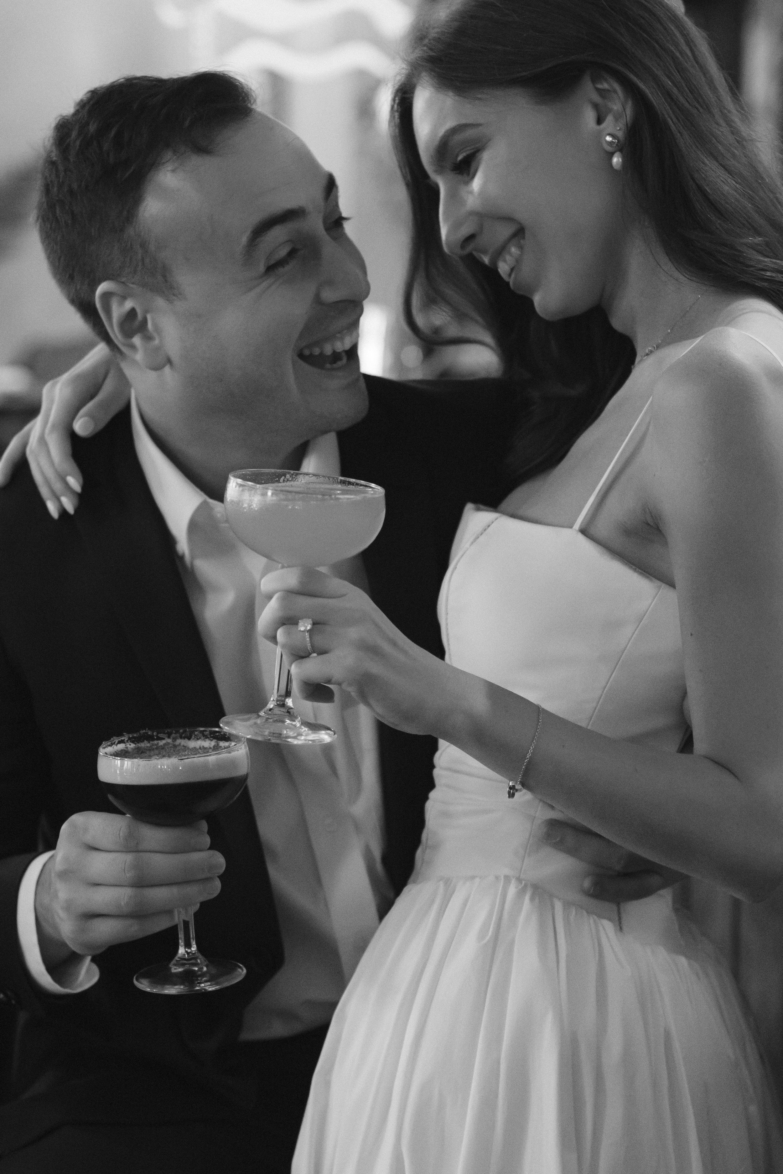 Couple toasting with cocktails, shot by documentary wedding photographer
