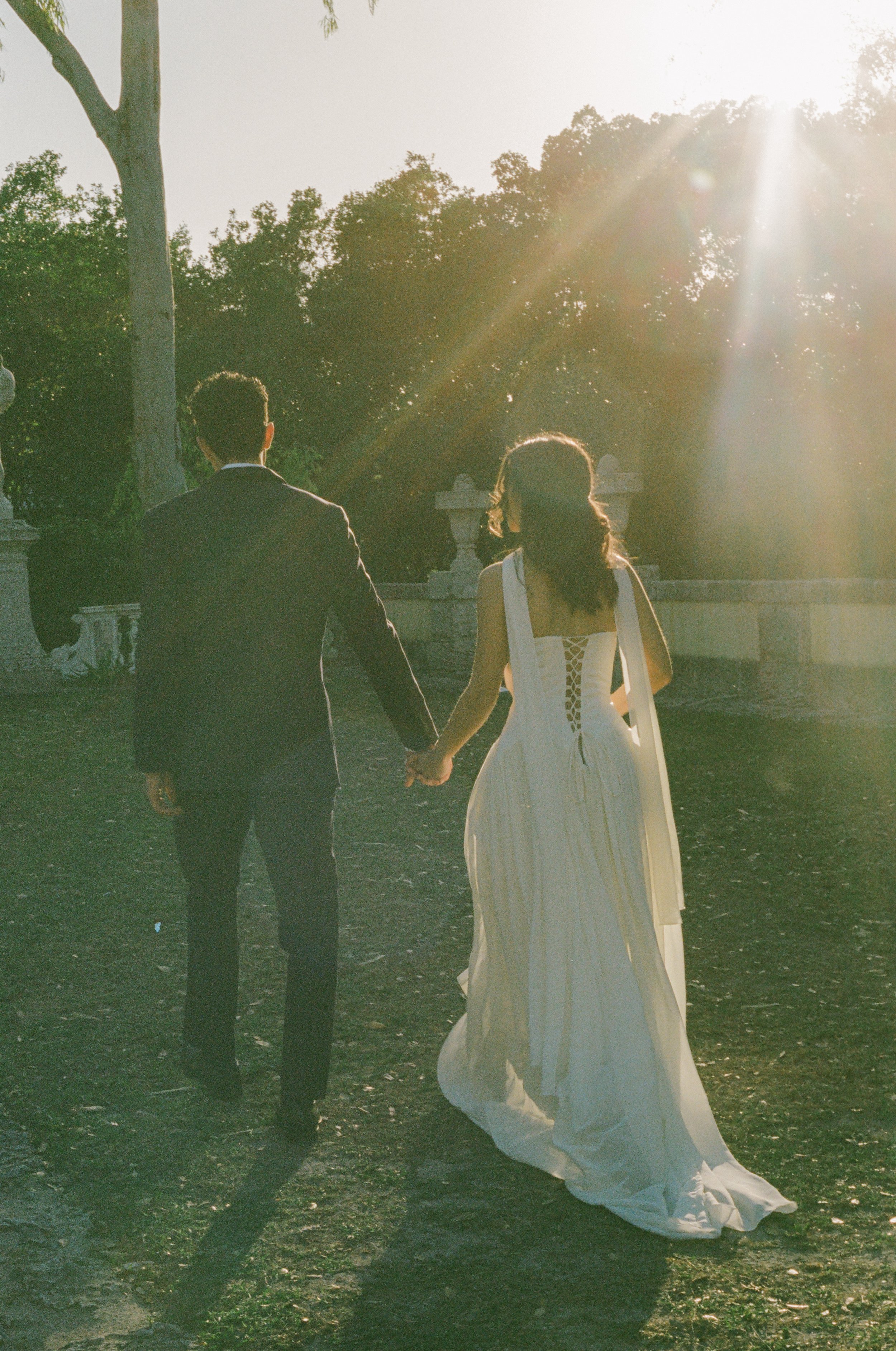 Couple walking into golden light, sunset captured in documentary style wedding photography