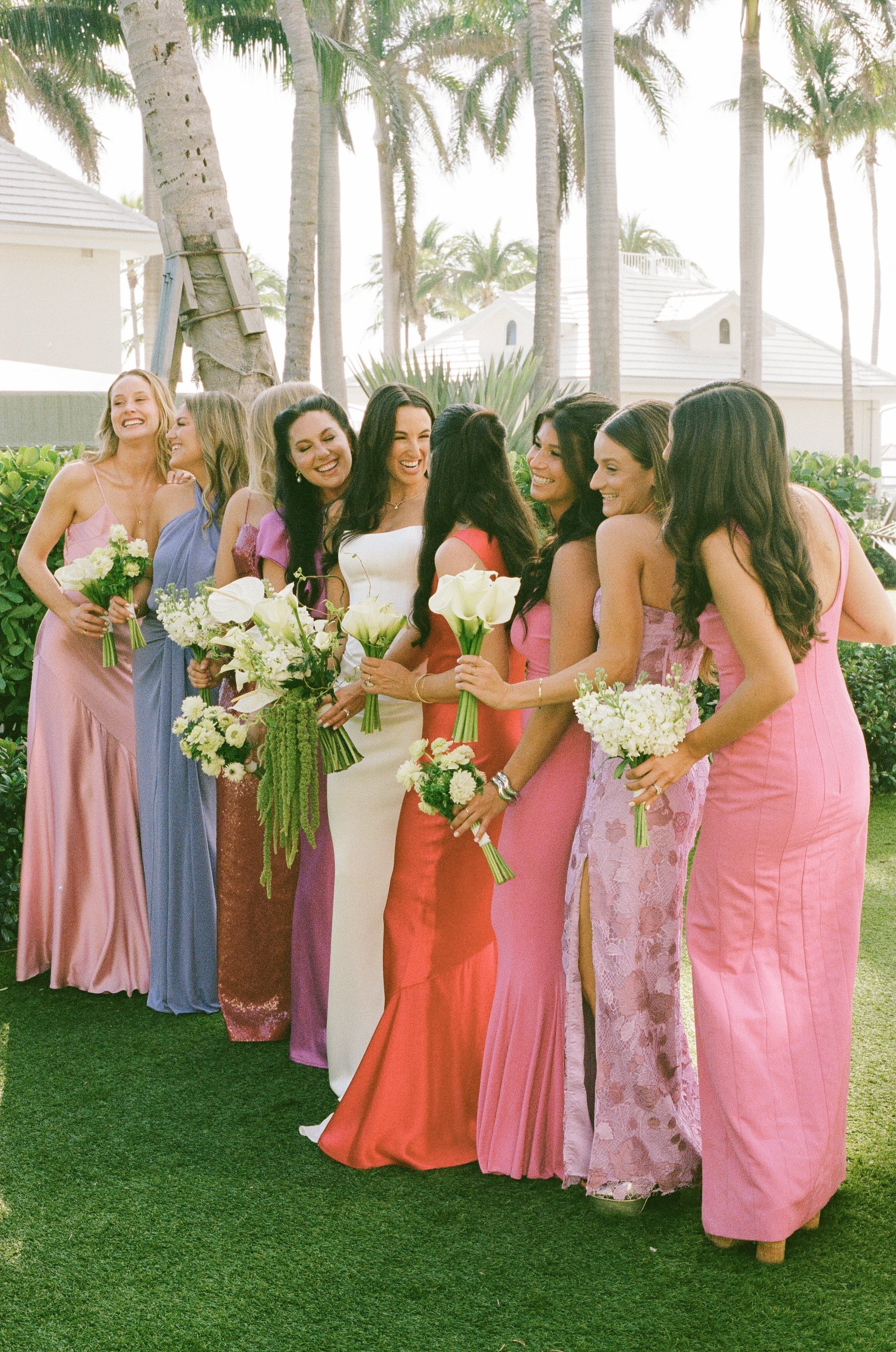 Bridesmaids laugh with bride outdoors, group moment in documentary style wedding photography