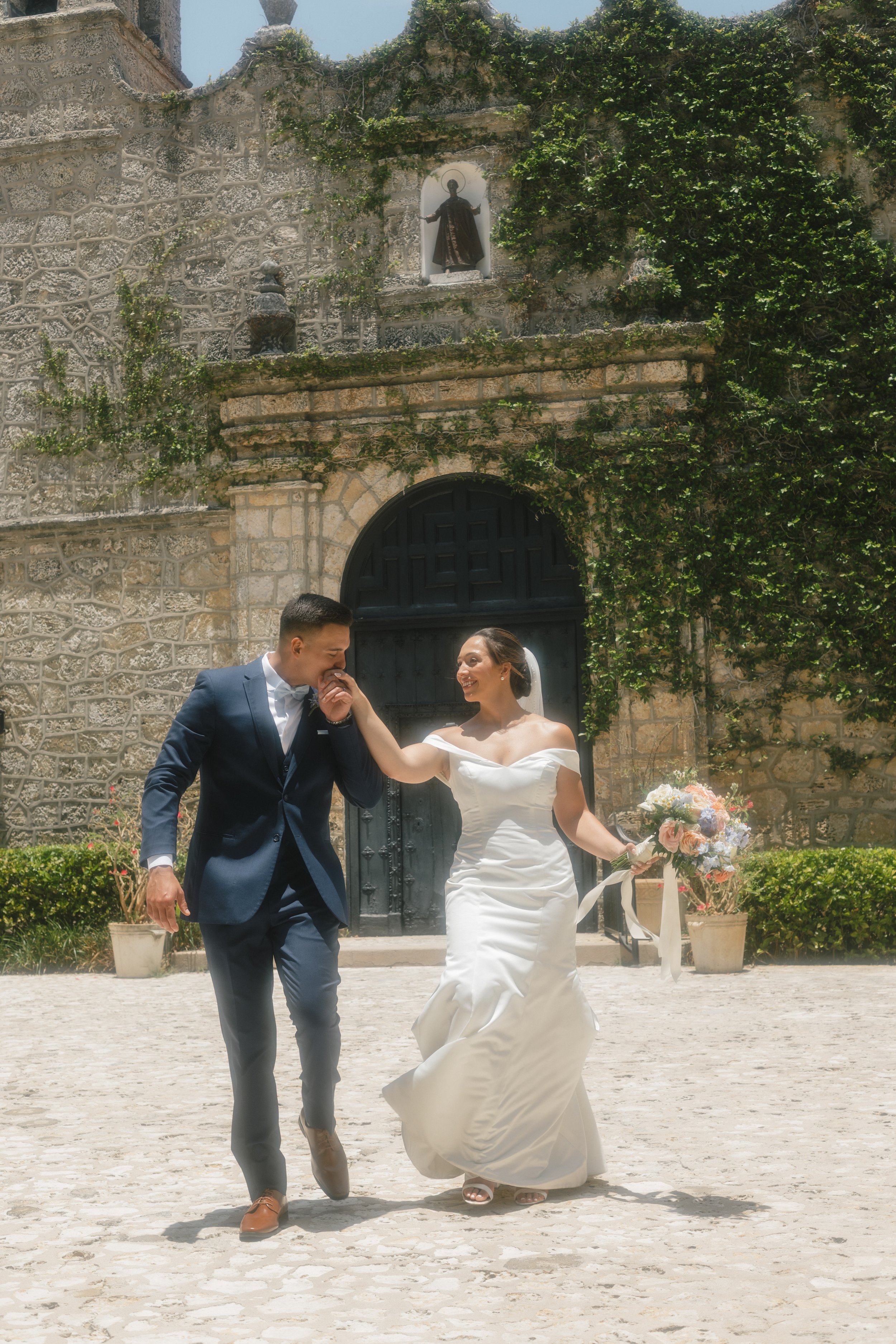 Bride and groom walking outside chapel, joyful moment in documentary style wedding photography