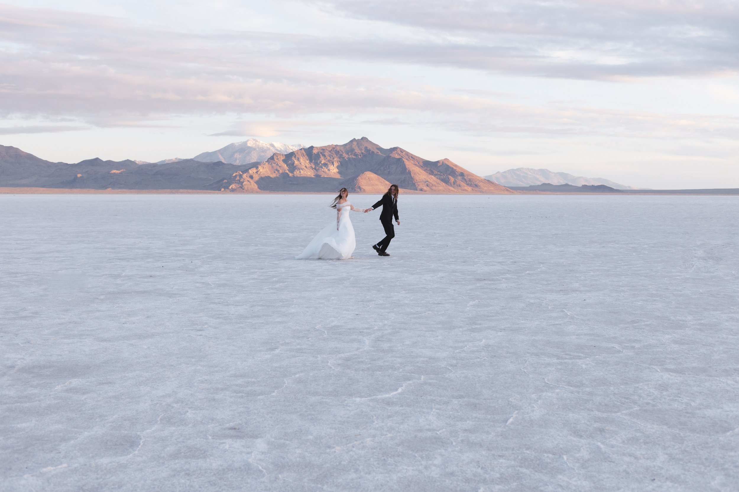 Couple runs across salt flats, by documentary wedding photographer