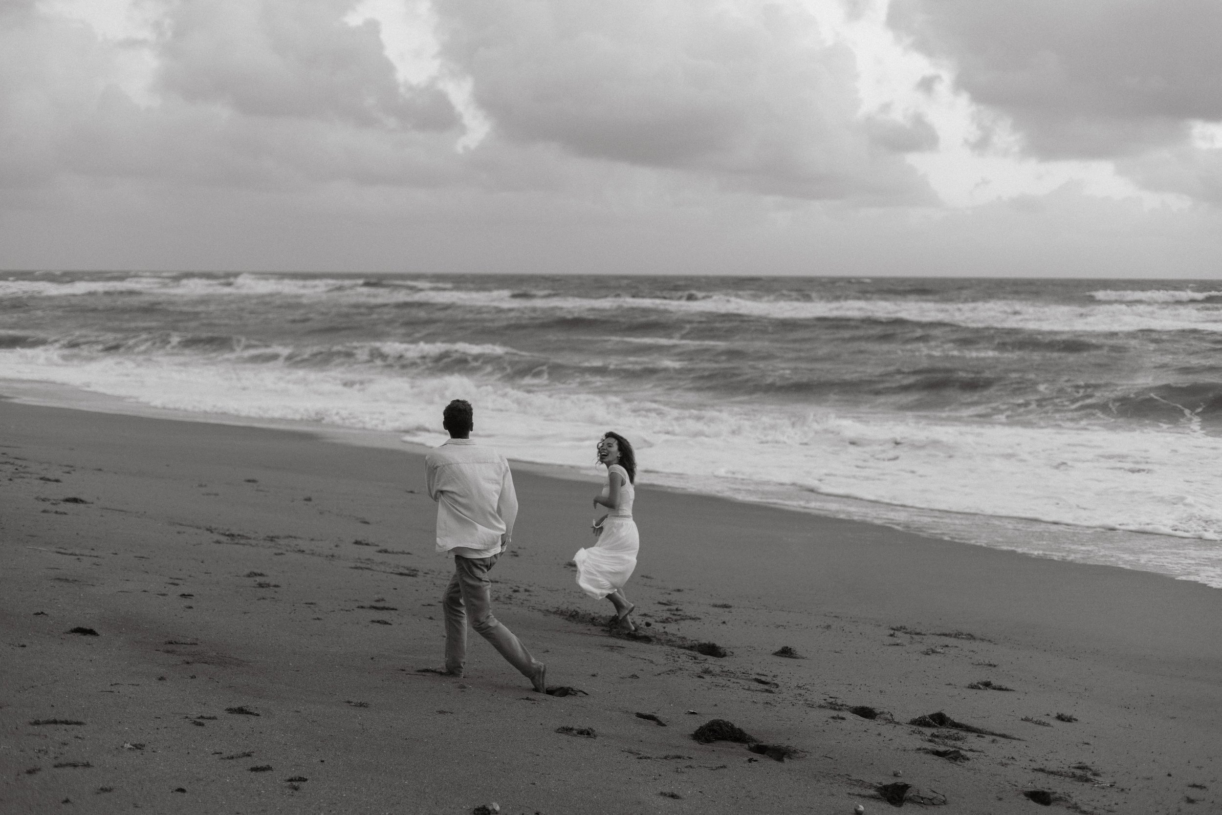 Couple walking along shoreline, captured by documentary wedding photographer