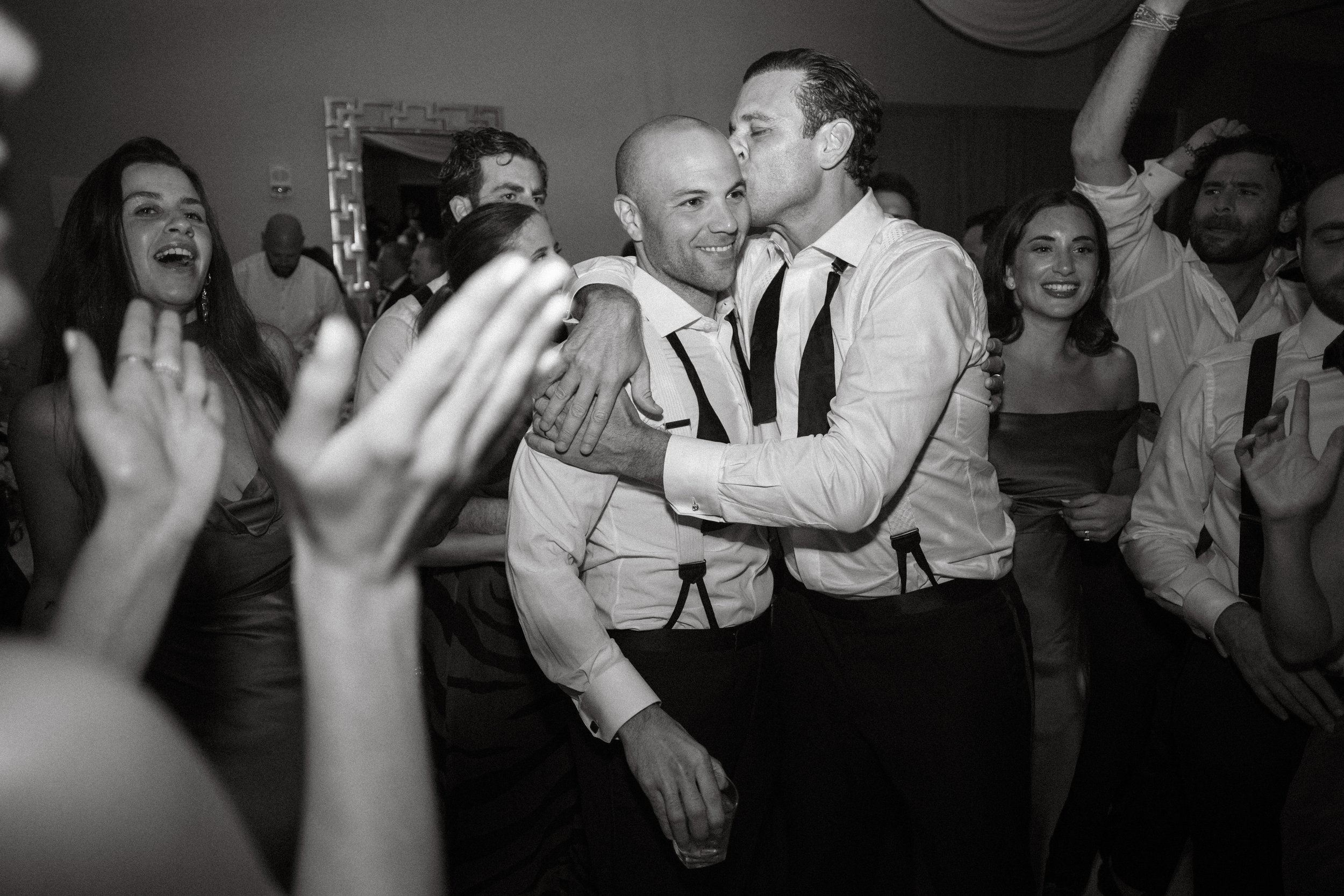 Guests cheering with drinks at reception, real moment in documentary style wedding photography
