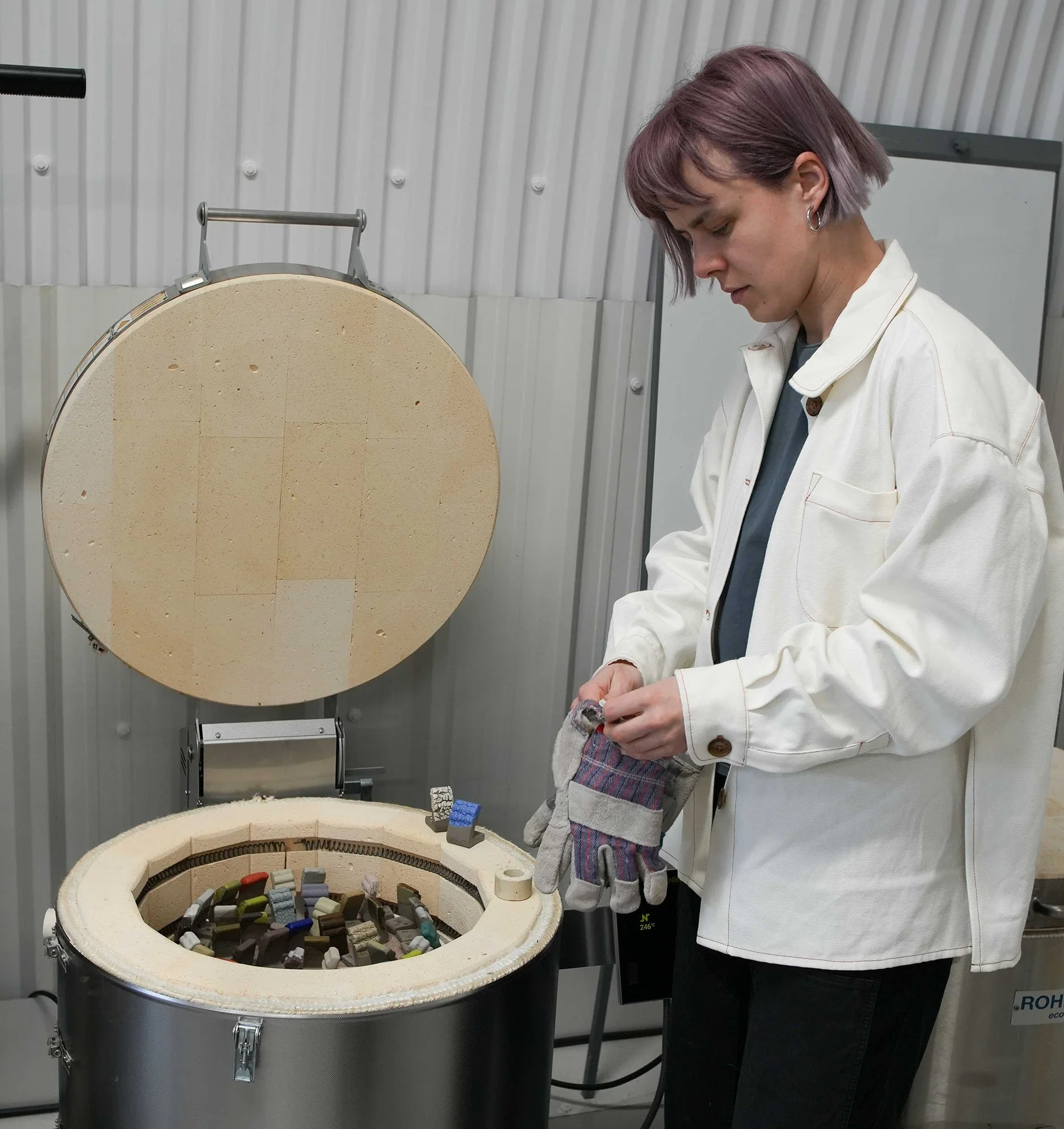female stood next to open kiln