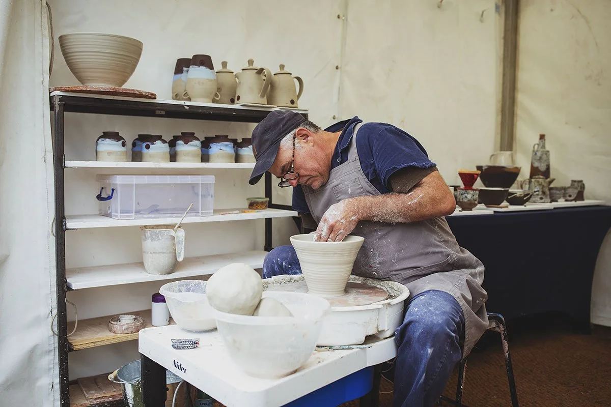 Male ceramic artists at potters wheel