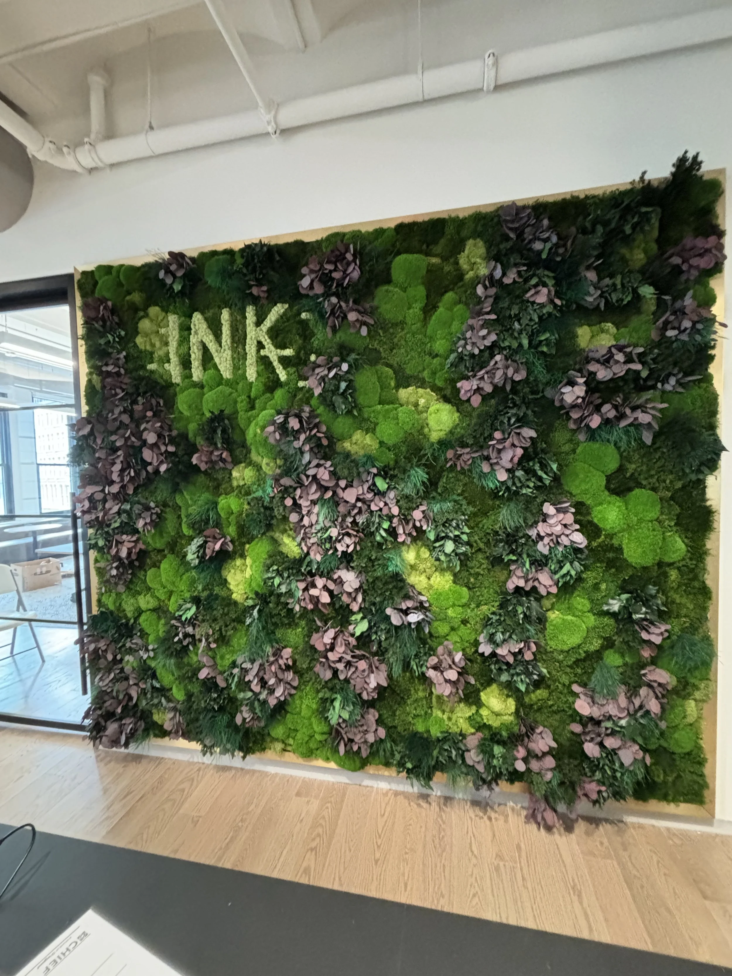 A sculptural botanical installation combining preserved materials, folia and floral accents.