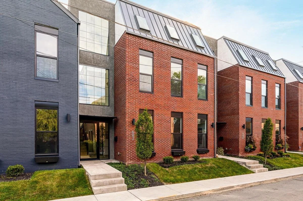 Architectural row of modern townhomes in Columbus, Ohio, featuring sleek designs with brick and dark gray facades, developed by DEV Partners, illustrating attractive investment opportunities in urban real estate developments.