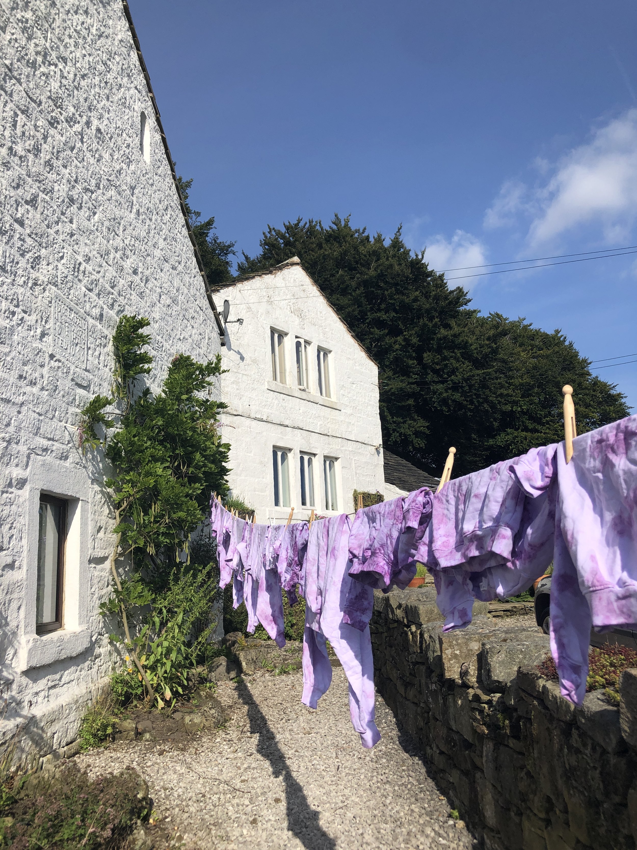 Graphic of Kids Positive Behaviour Relaxed Sweatshirt - Purple Tie Dye hand dyed in Todmorden on washing line