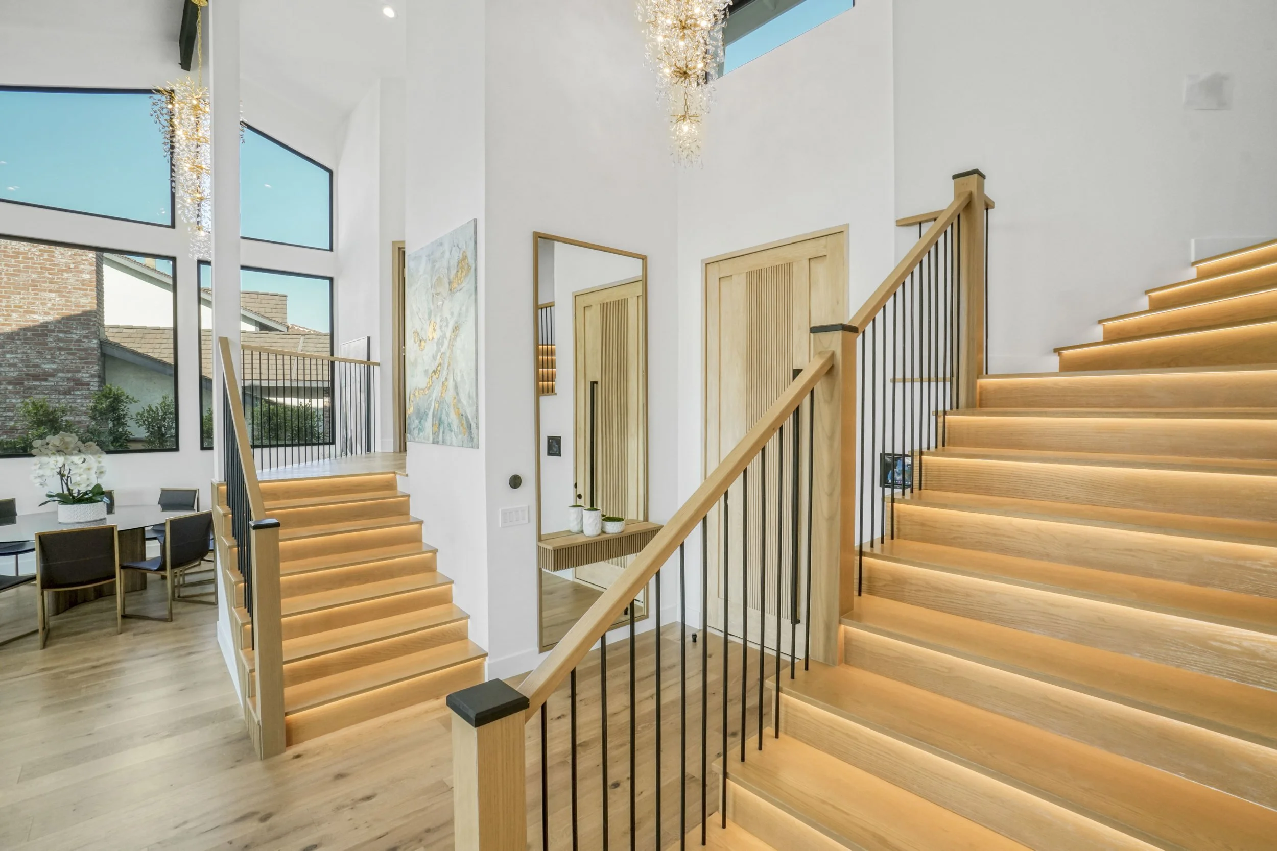 Entry hall with a light wood staircase and metal railing