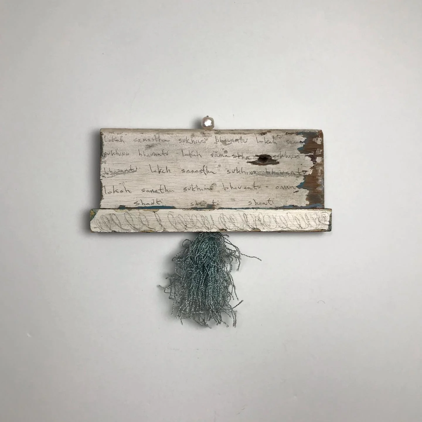 World Prayer. Mantra series.
May all beings everywhere in all the worlds be happy and free. 
5&rdquo;h x 6&rdquo;w x .5&rdquo;d
Pencil on reclaimed wood, freshwater pearl, fiber. 

#lokahsamastahsukhinobhavantu  #sacredchant #worldprayer #kirtan #san