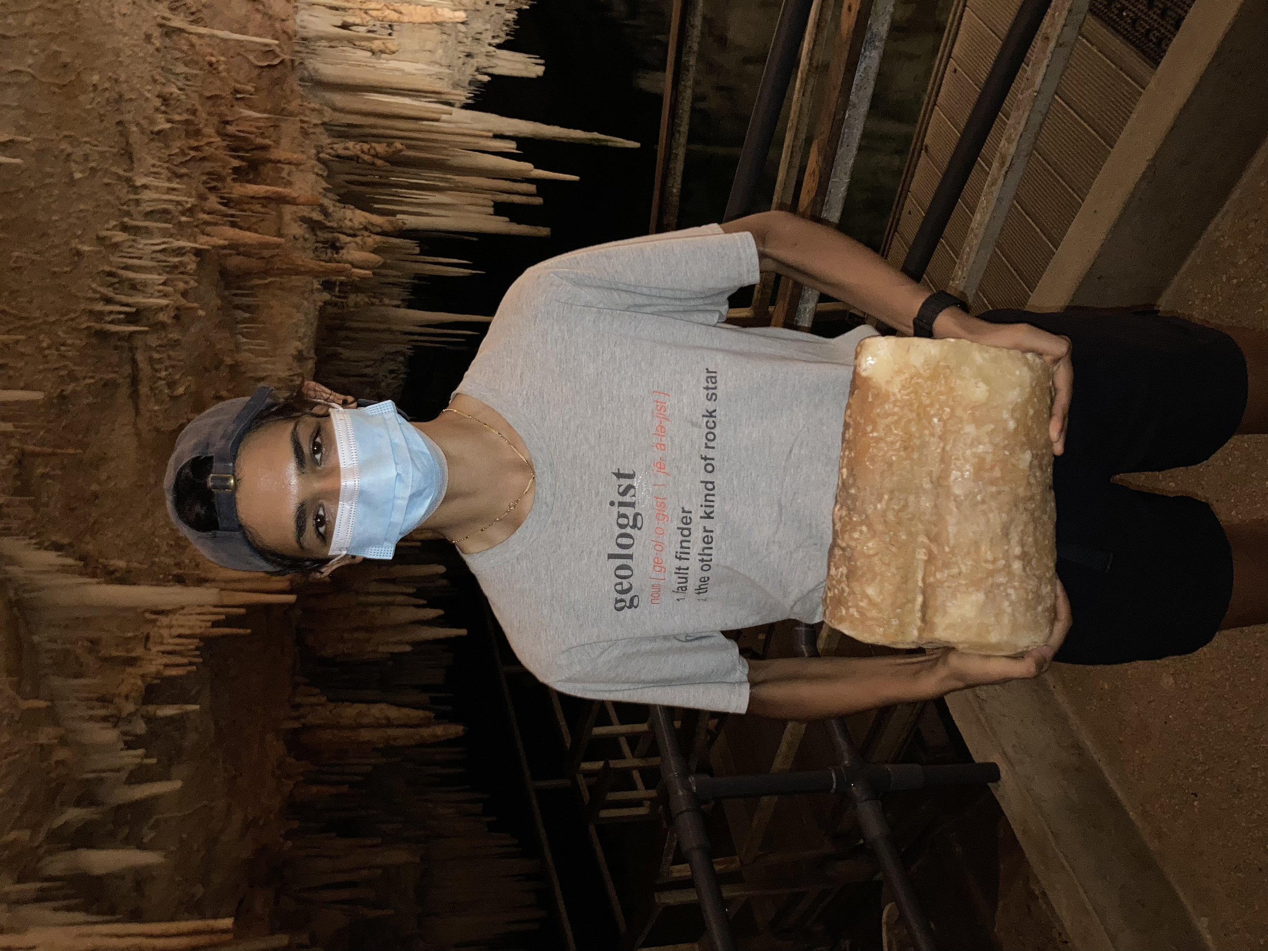 Holding a stalactite in a cave in Bermuda
