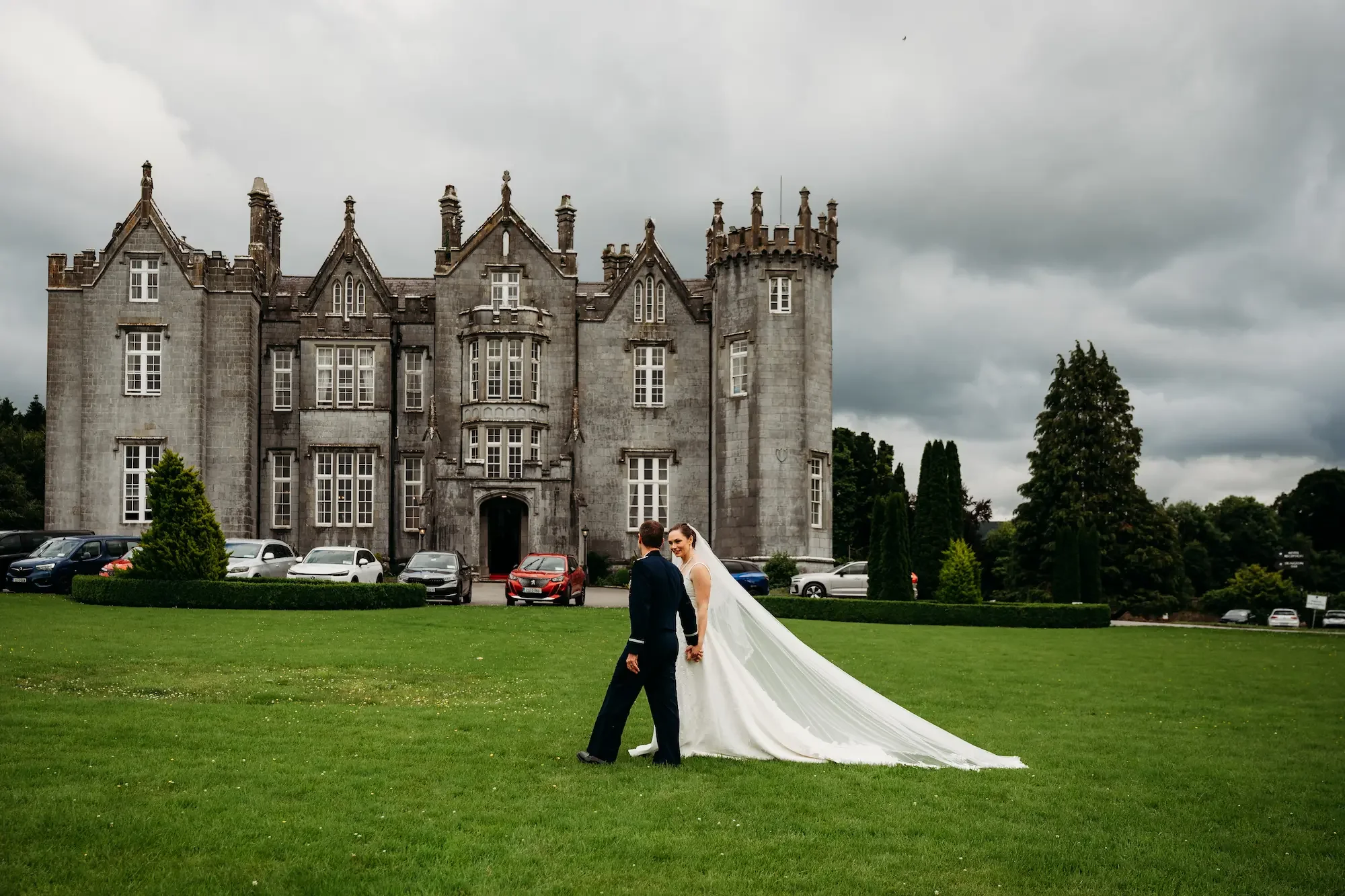 Krystal and Kurtis holding hands on the green lawn of Kinnitty Castle, Co. Offaly