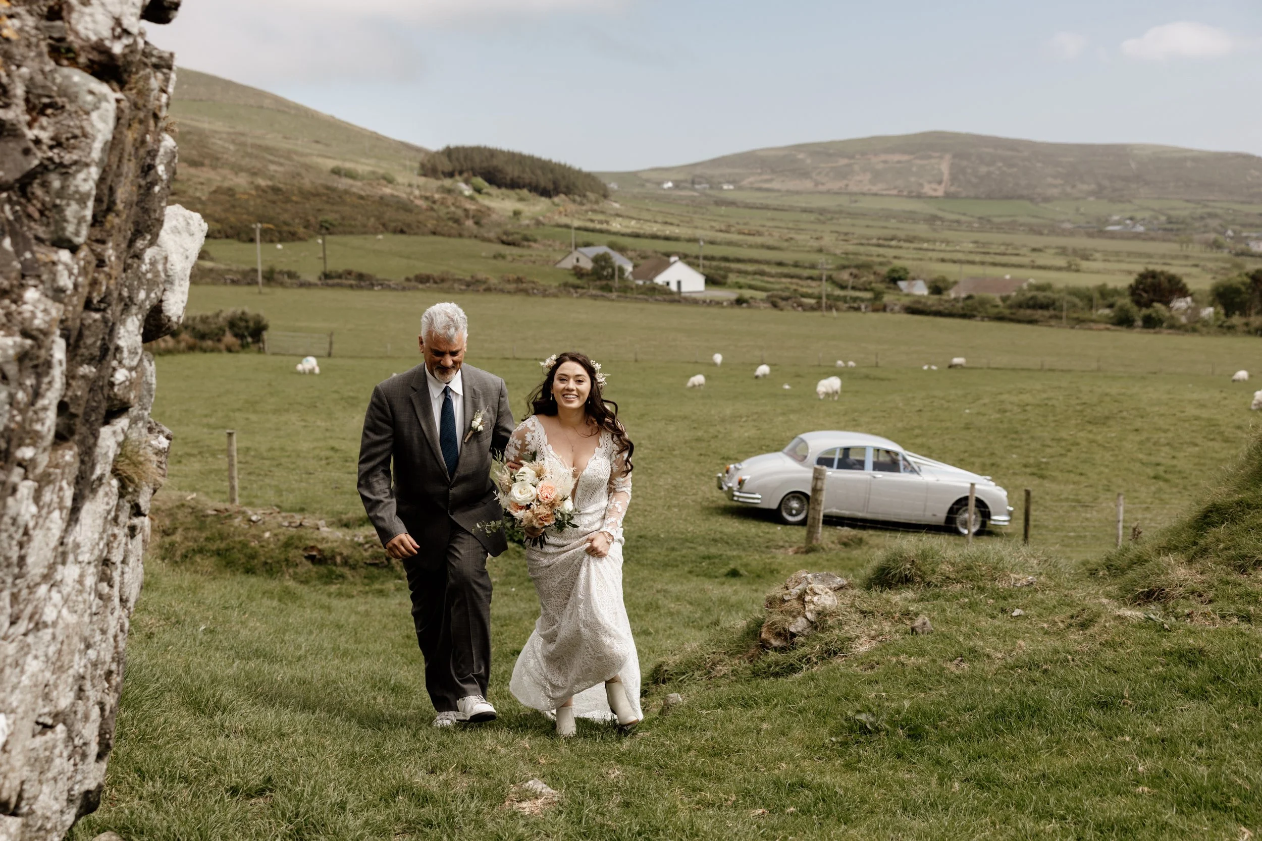 The couple together in the ruins of Rahinnane Castle with the Dingle Peninsula behind them