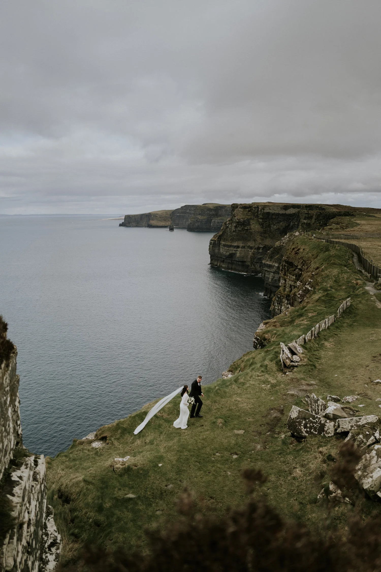 Wedding couple walking along the Cliffs of Moher
