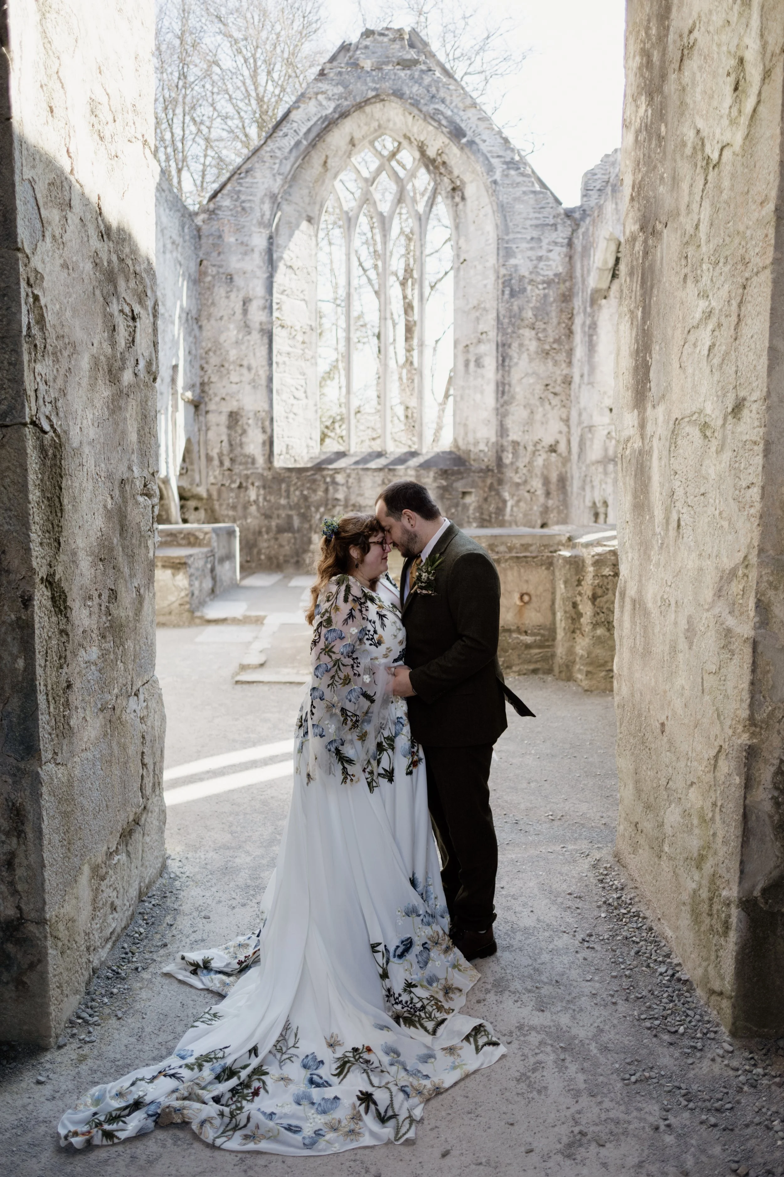 Kelli and Ethan embracing inside the historic ruins of Muckross Abbey