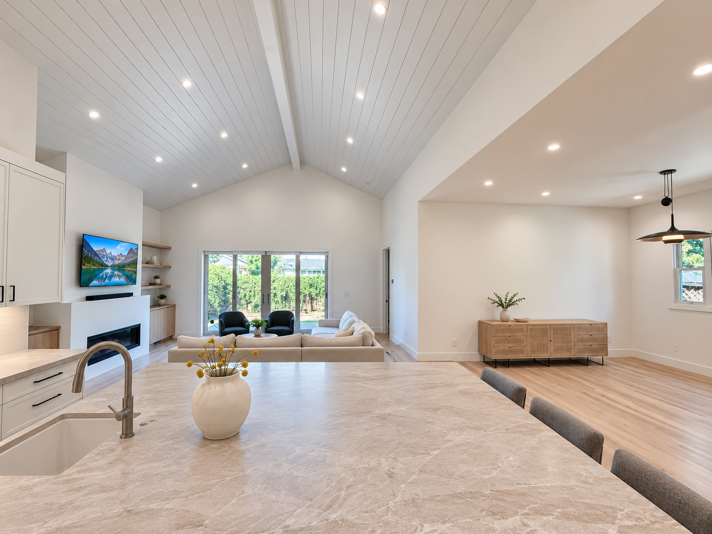 Vaulted great room with recessed lighting and a view toward the garden.
