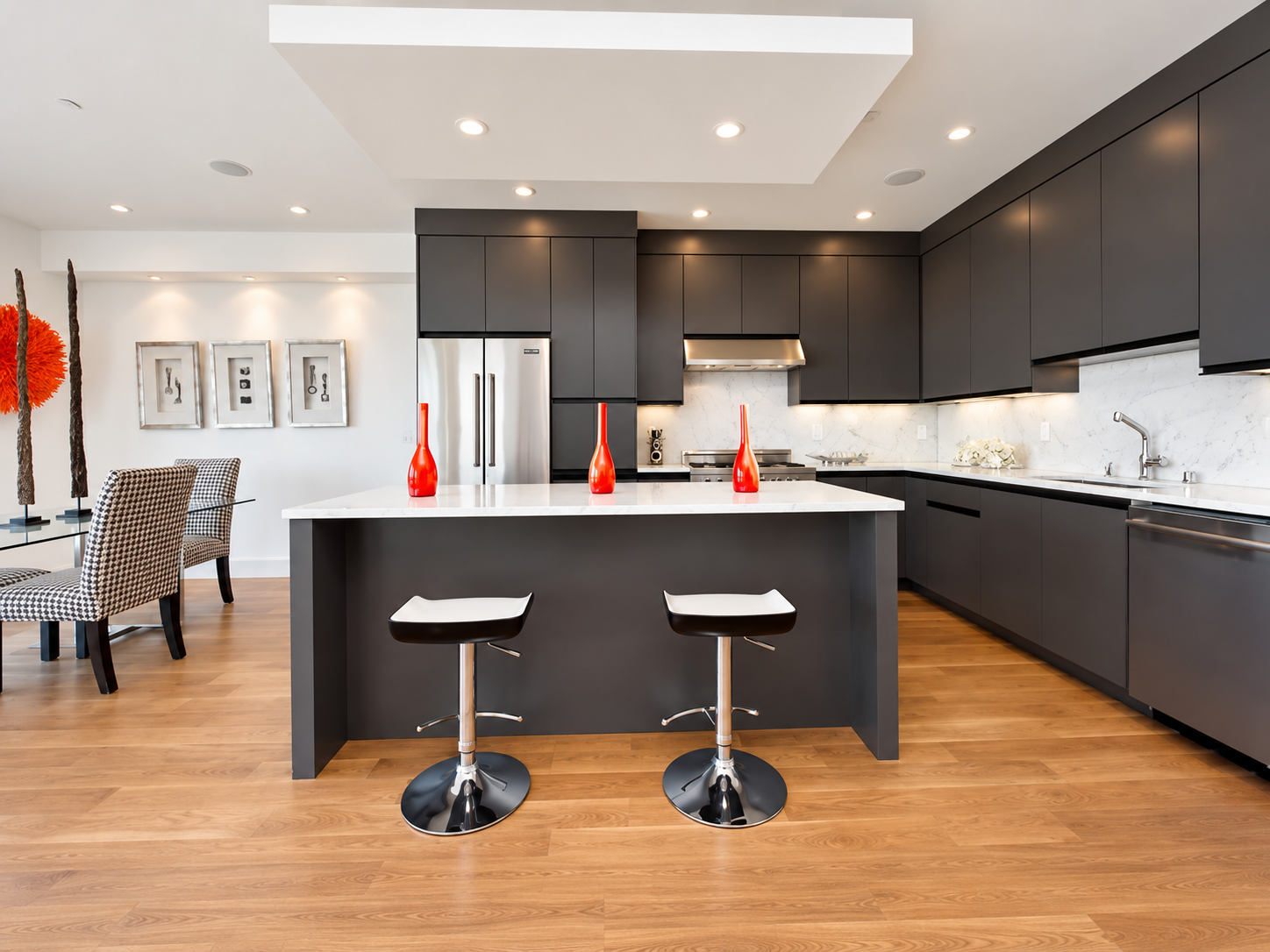 Contemporary kitchen with charcoal cabinetry, white counters, and island seating.