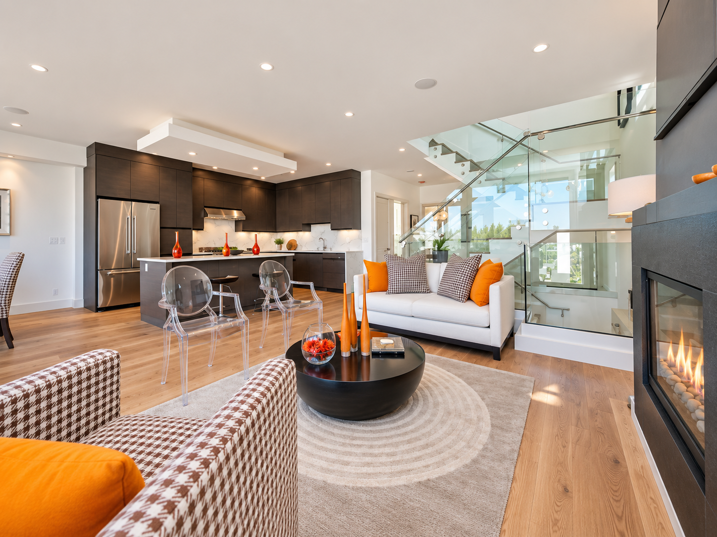 Open-plan living room and kitchen with wood floors and expansive windows.