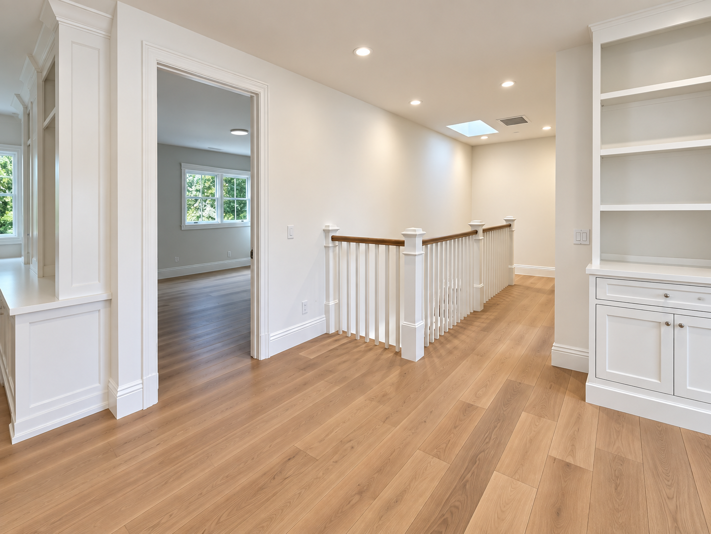 Upstairs landing with wood floors, a stair railing, and built-in cabinetry.