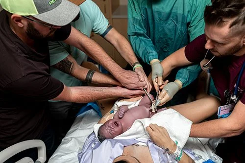 Surrogate dads both cut the cord together.