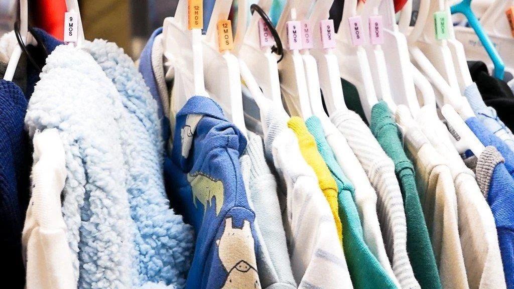 Stacks of Pampers baby diapers in packages, including Baby Dry and Swaddlers varieties.