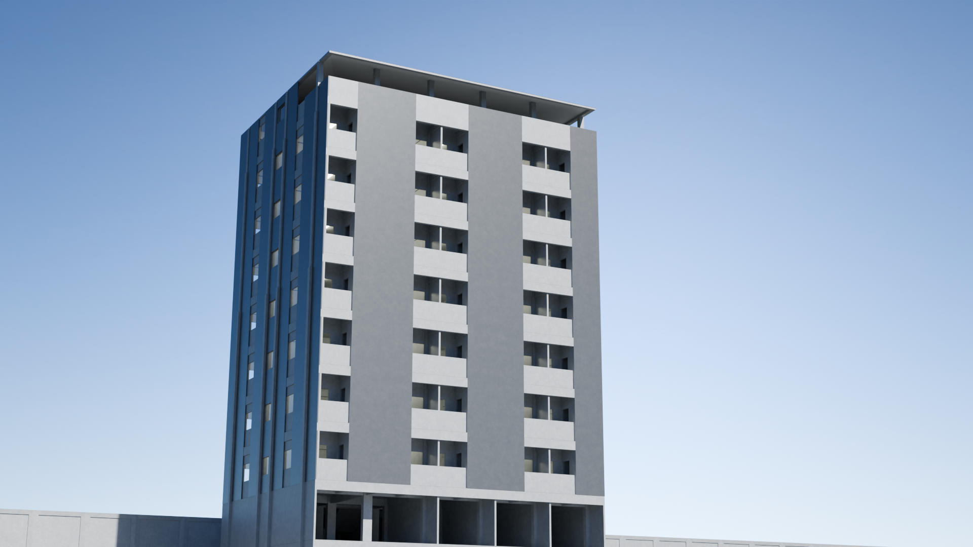 A modern high-rise building with a gray facade and multiple balconies, set against a clear blue sky.
