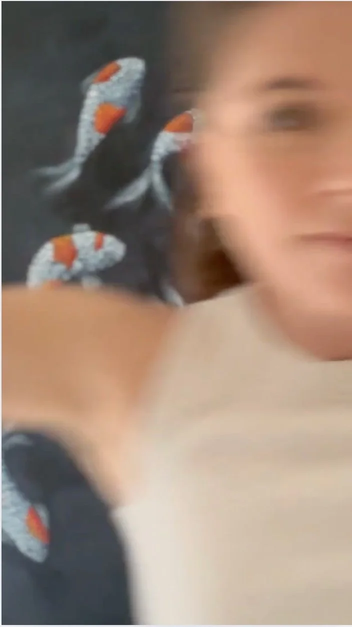 Leah East,  artist, with blurred features and a background featuring her Feng Shui inspired painting of koi fish, titled 'Just keep swimming'.