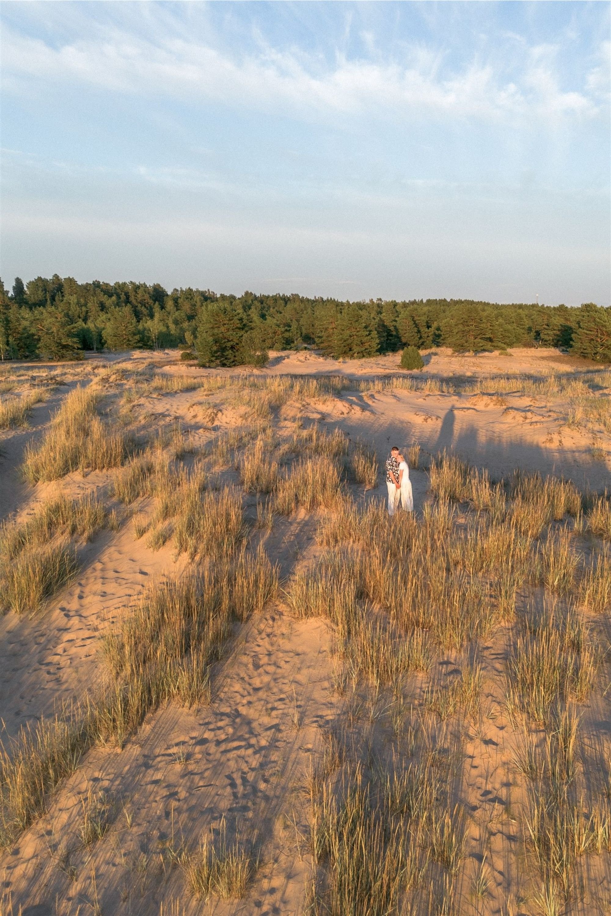 Romanttinen pariskuntakuvaus Yyterin hiekkarannalla, jossa auringonlasku ja miljöön rauhallisuus korostavat hetken intiimiä tunnelmaa. Dronekuvaus. Ilmakuvaus.
